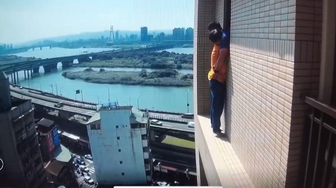 砍人男子企圖從陽台逃脫，數度攀爬公寓外牆，畫面令人看了膽戰心驚。（翻攝畫面）