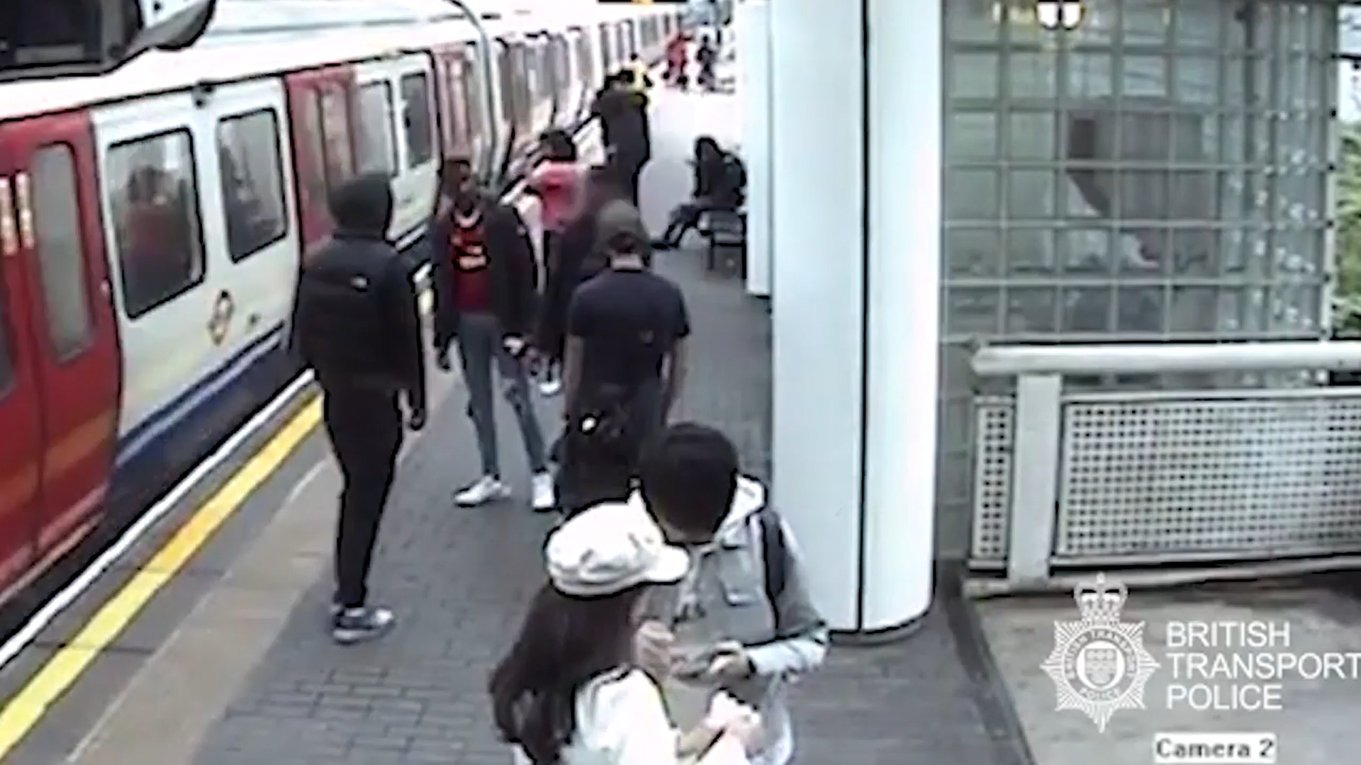 監視器拍下凶嫌越過空橋、刺殺、逃跑的過程。死者（紅衣）死前還穿著球隊T恤。（翻攝自英國運輸警察）