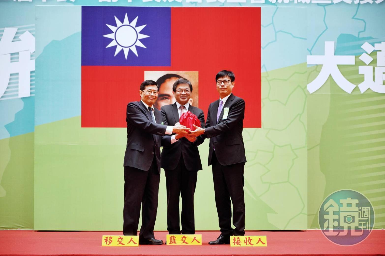 典禮上,代理市長楊明州(左)將印信交給新任市長陳其邁(右),由行政院祕書長李孟諺(中)監交。