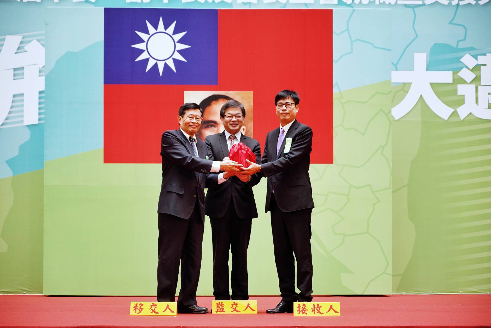 典禮上,代理市長楊明州(左)將印信交給新任市長陳其邁(右),由行政院祕書長李孟諺(中)監交。