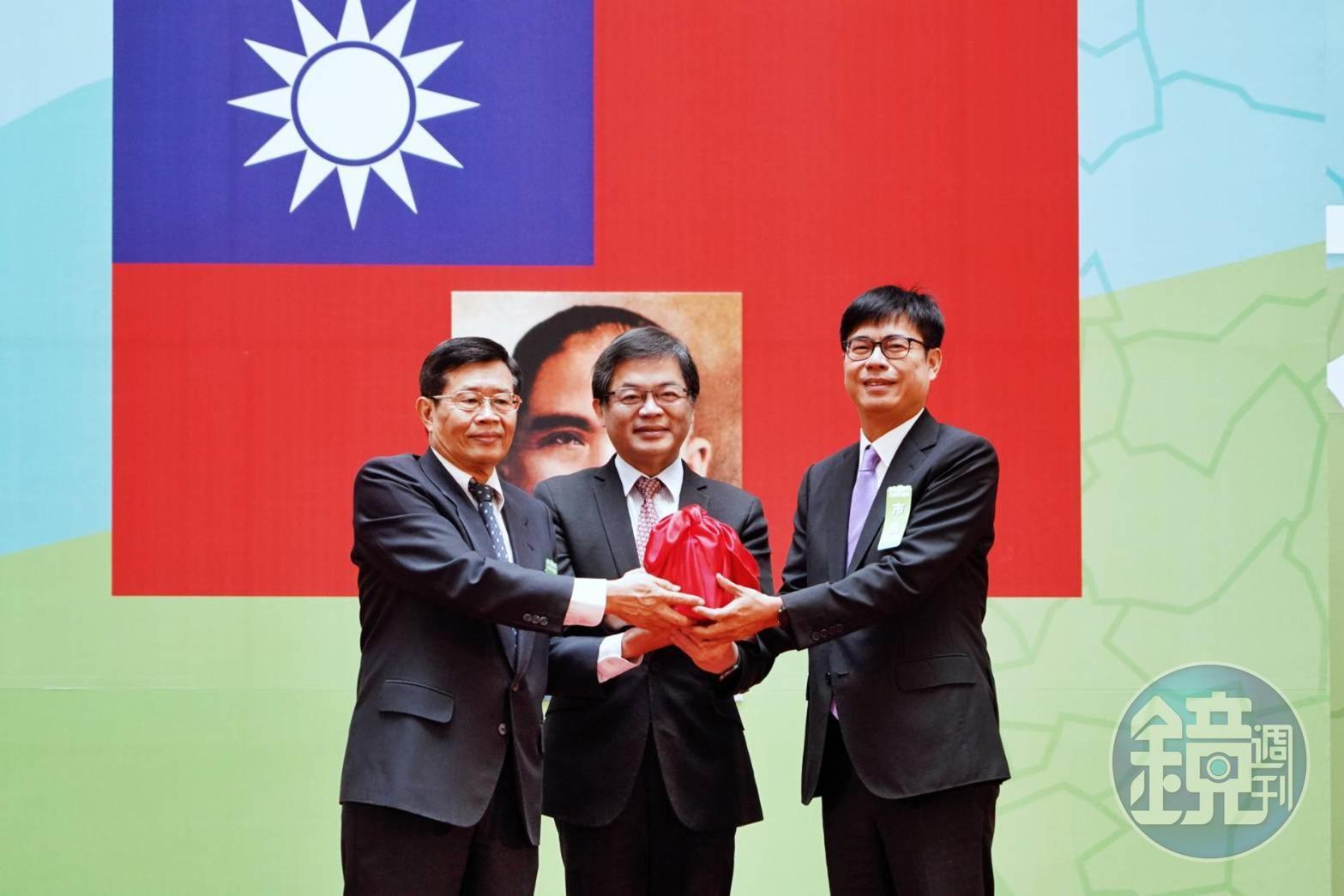 典禮上,代理市長楊明州(左)將印信交給新任市長陳其邁(右),由行政院祕書長李孟諺(中)監交。