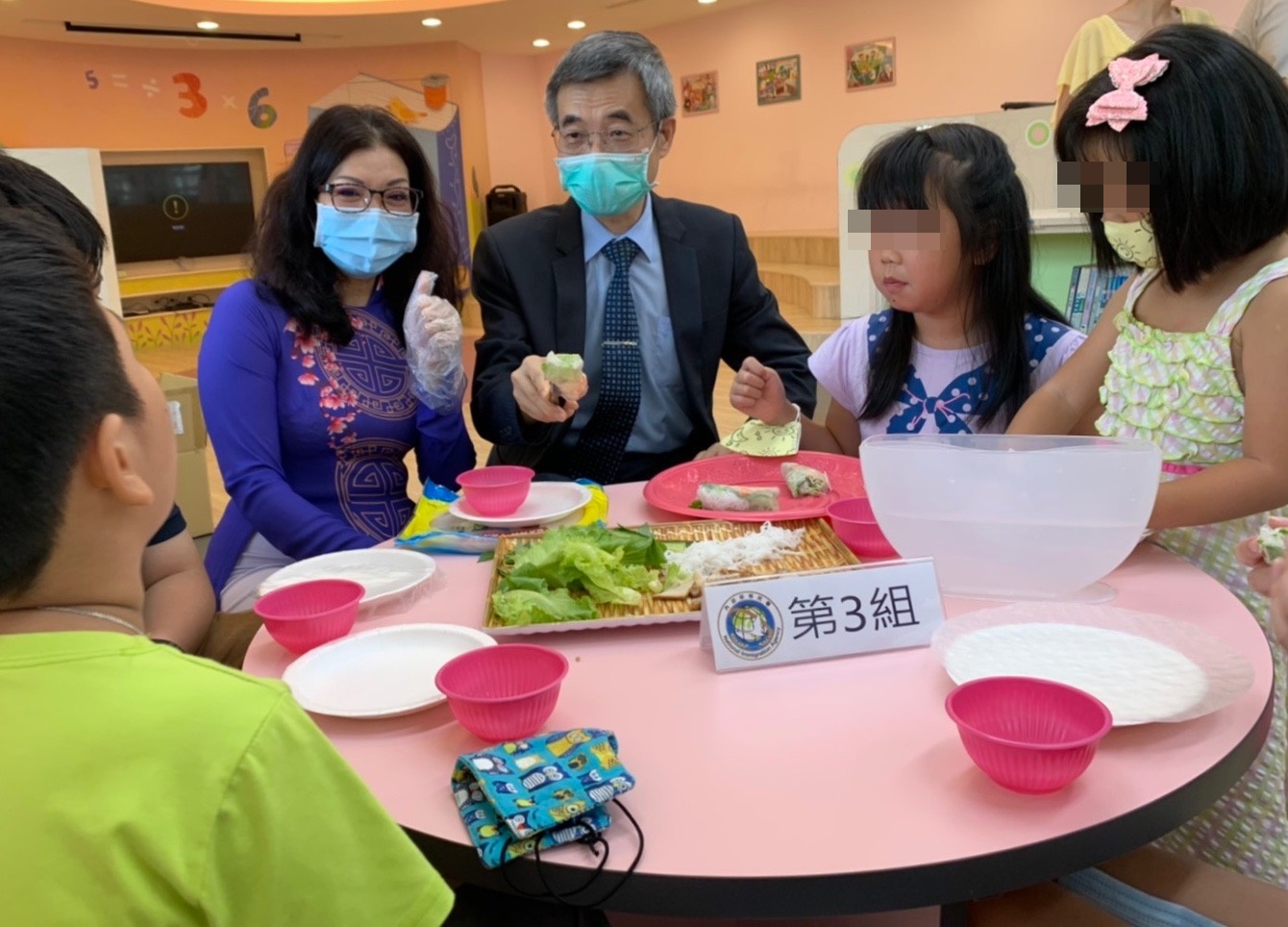 移民署梁副署長（右三）、新住民媽媽武氏芳恆（左三）與新住民小朋友一起分享現場DIY的越南春捲。