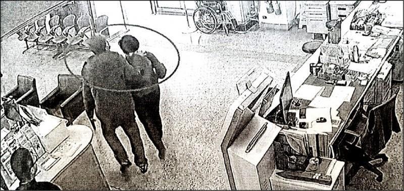 張展昭用手掐住杜女的脖子,把她架離服務櫃台往大門走去。(讀者提供)