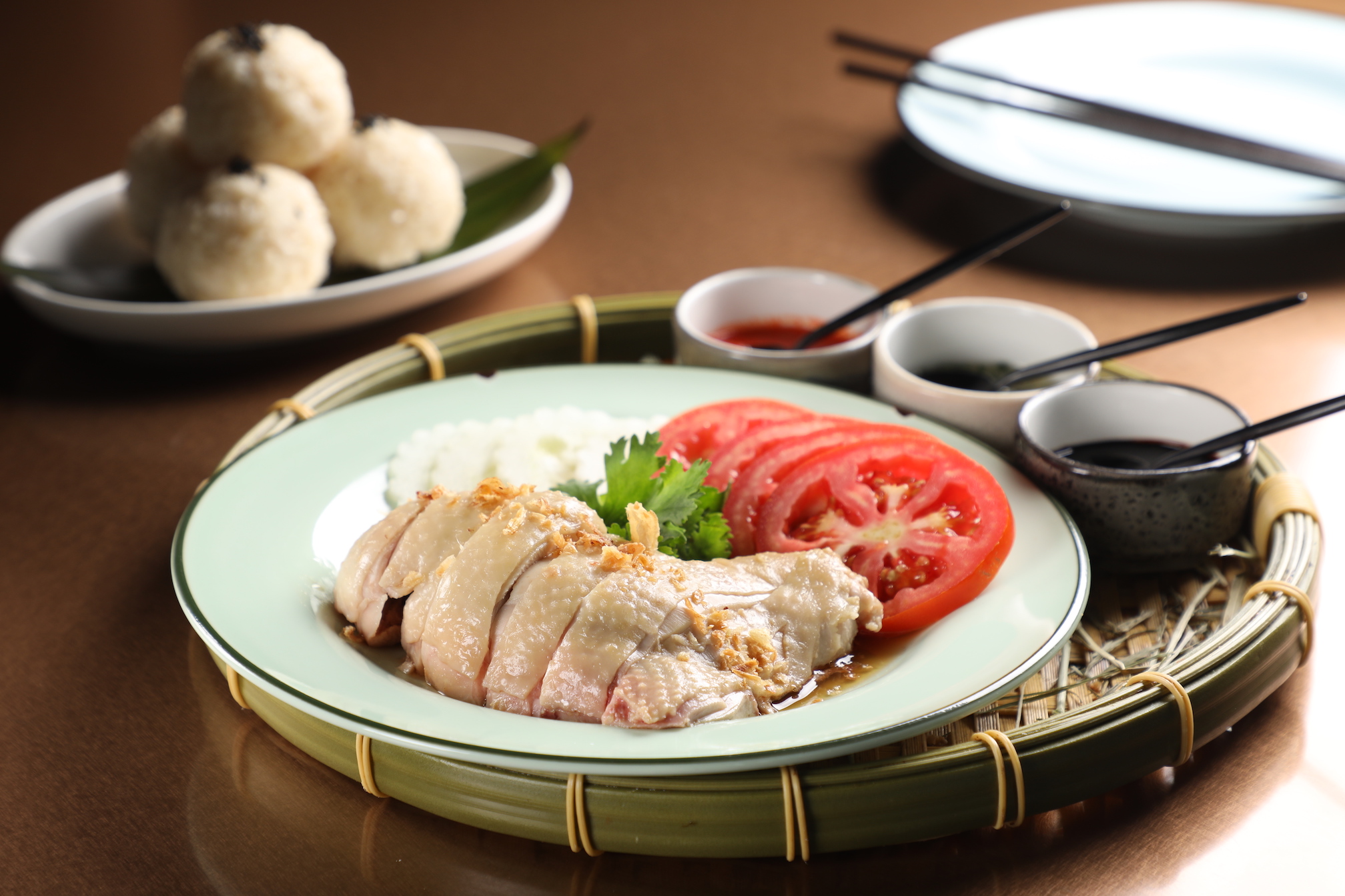 「海南雞飯」搭配黑醬油、薑蔥、辣椒三種醬料，要壓扁飯球一起吃。（480元／份）