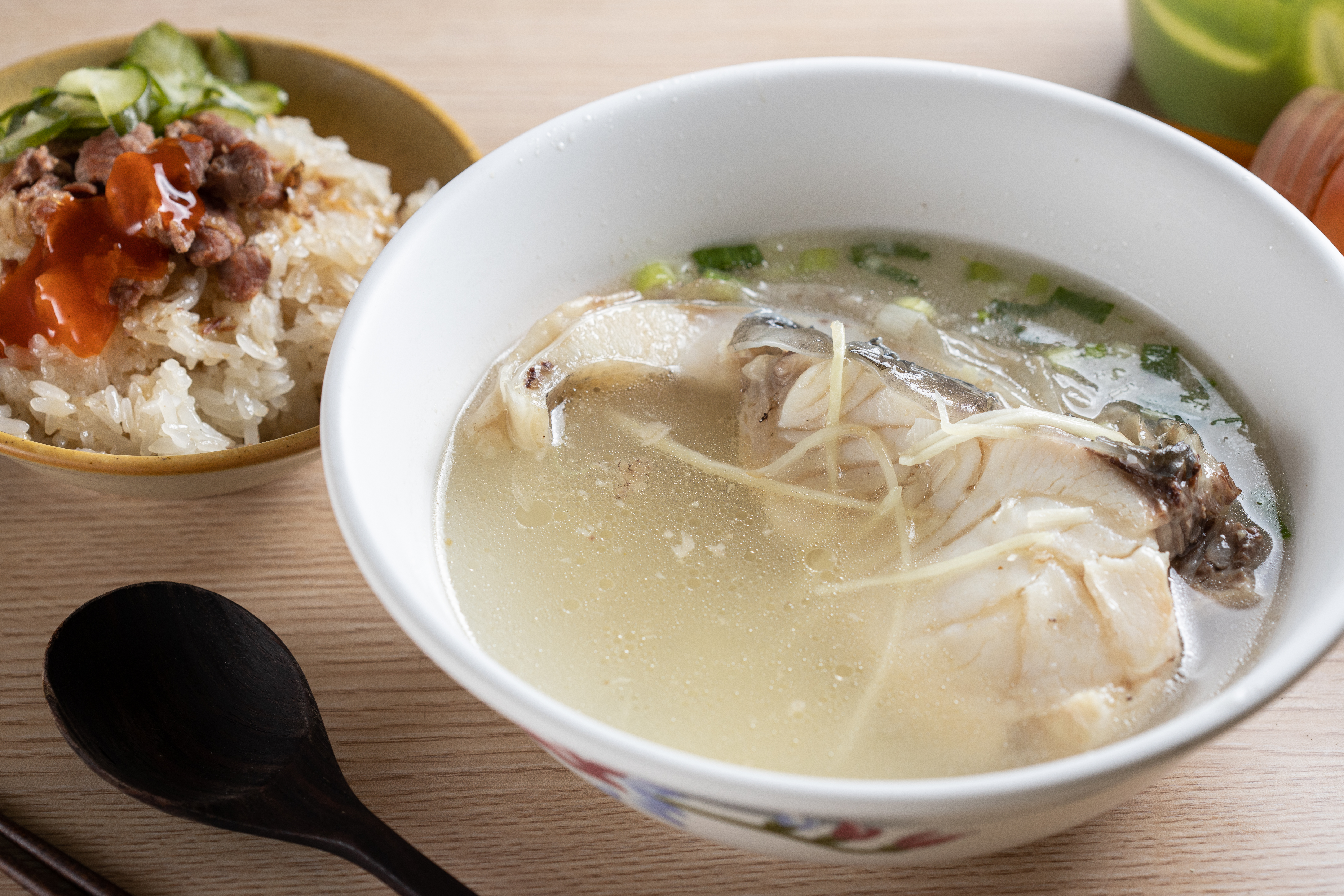 「草魚湯」（前，50元／碗）刺少肉Q，還可以點隔壁攤的「古早味米糕」（後，25元／小碗）來吃。