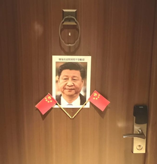門上出現習近平肖像,還在下方插了兩支五星旗,照片上更以繁體字寫著「壞鬼在這間房間不受歡迎」。(翻攝自Lumír Aschenbrenner臉書)