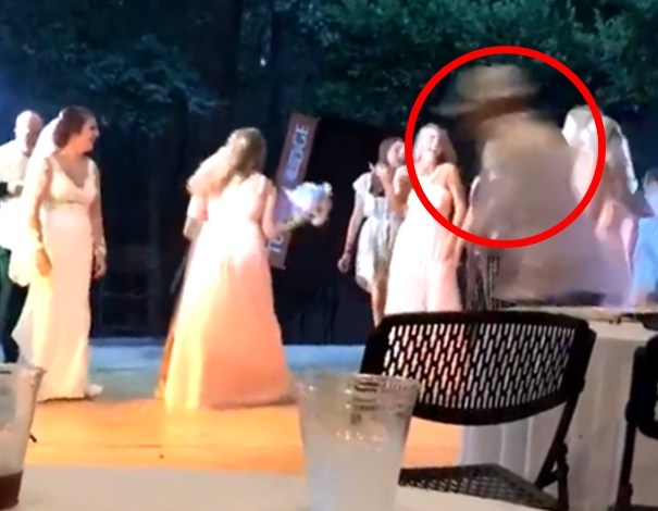 收到捧花的海莉比出勝利姿勢，男友內森卻在後面拔腿狂奔。（翻攝自影片）