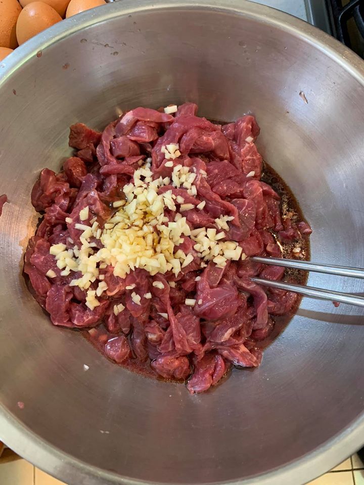 加入蒜末丶麻油及醬油醃牛肉。