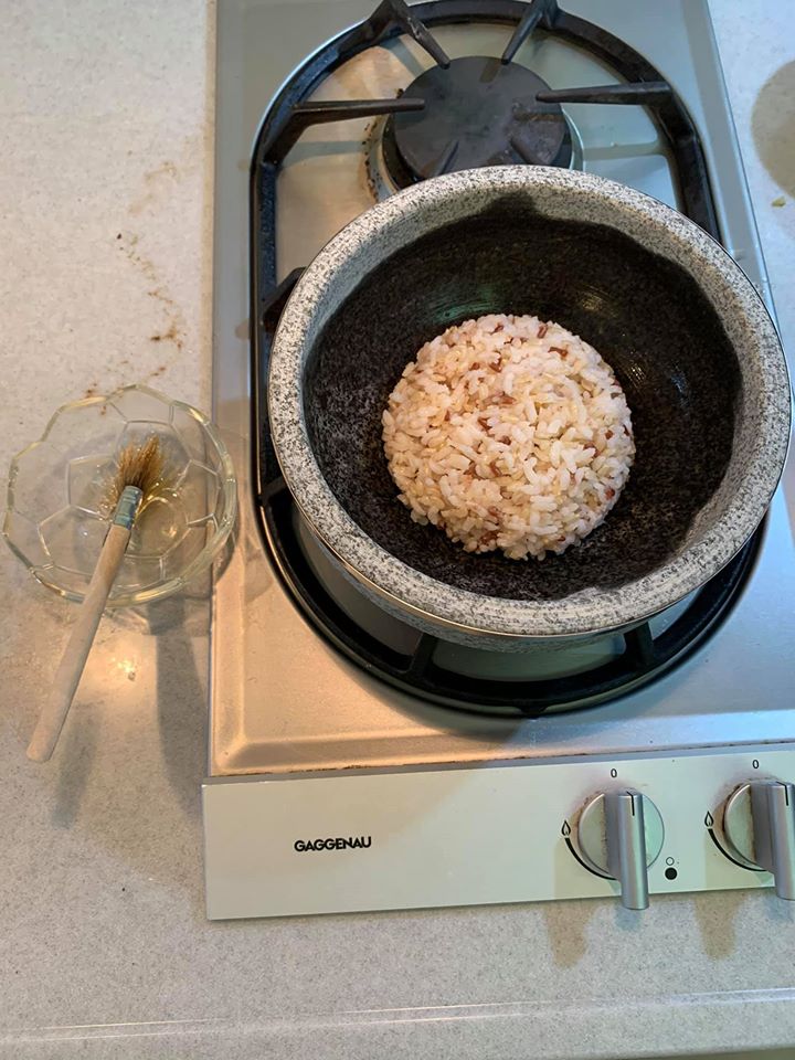 石鍋內部刷上香麻油，倒入一碗飯，鋪平。