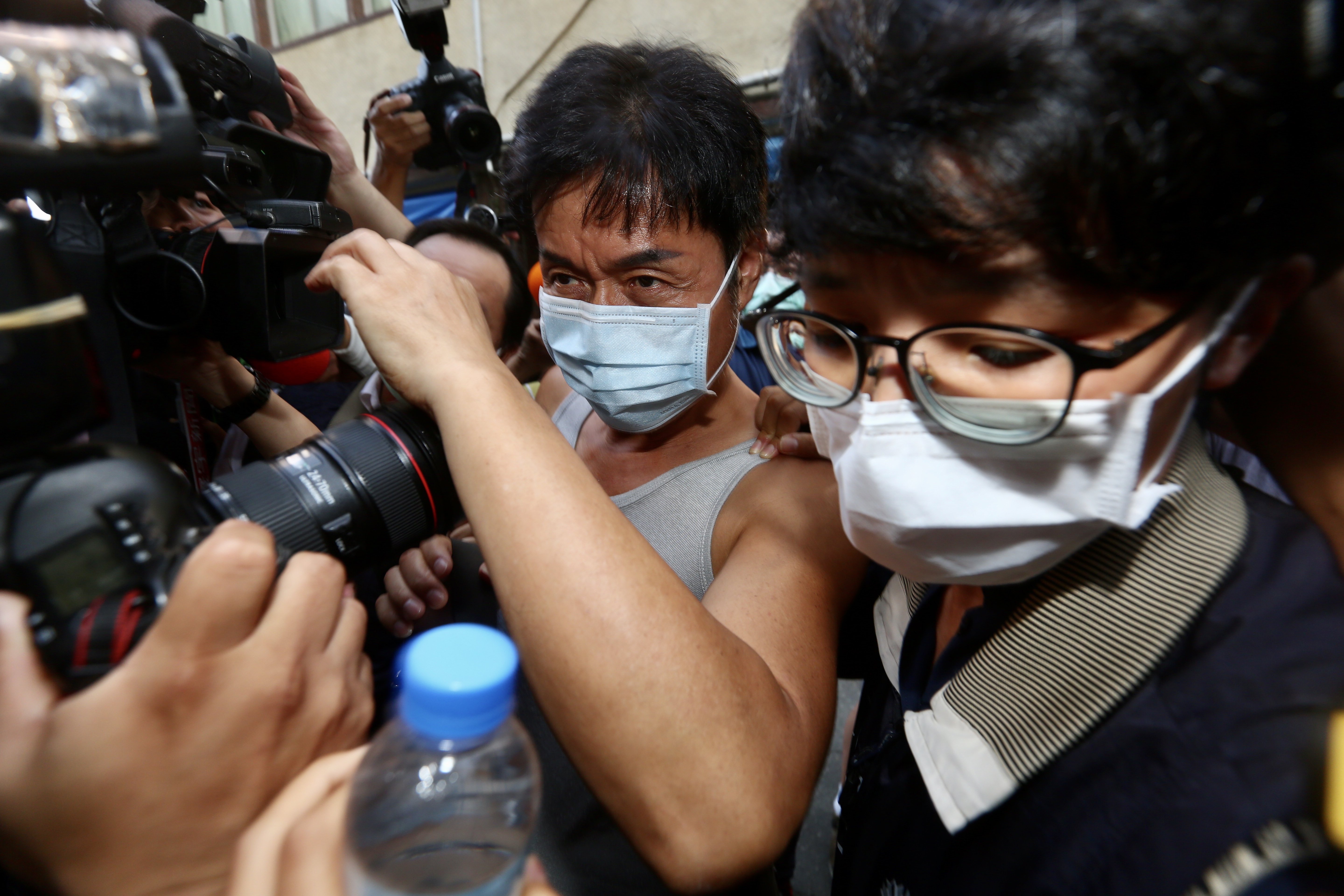 加利科技負責人林明進（中）在檢調陪同之下回到位在八里廠房。