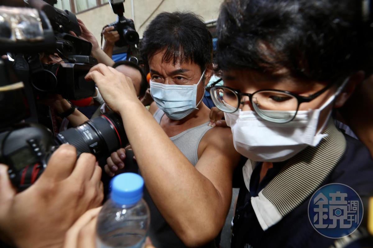 加利科技負責人林明進（中）在檢調陪同之下回到位在八里的廠房。