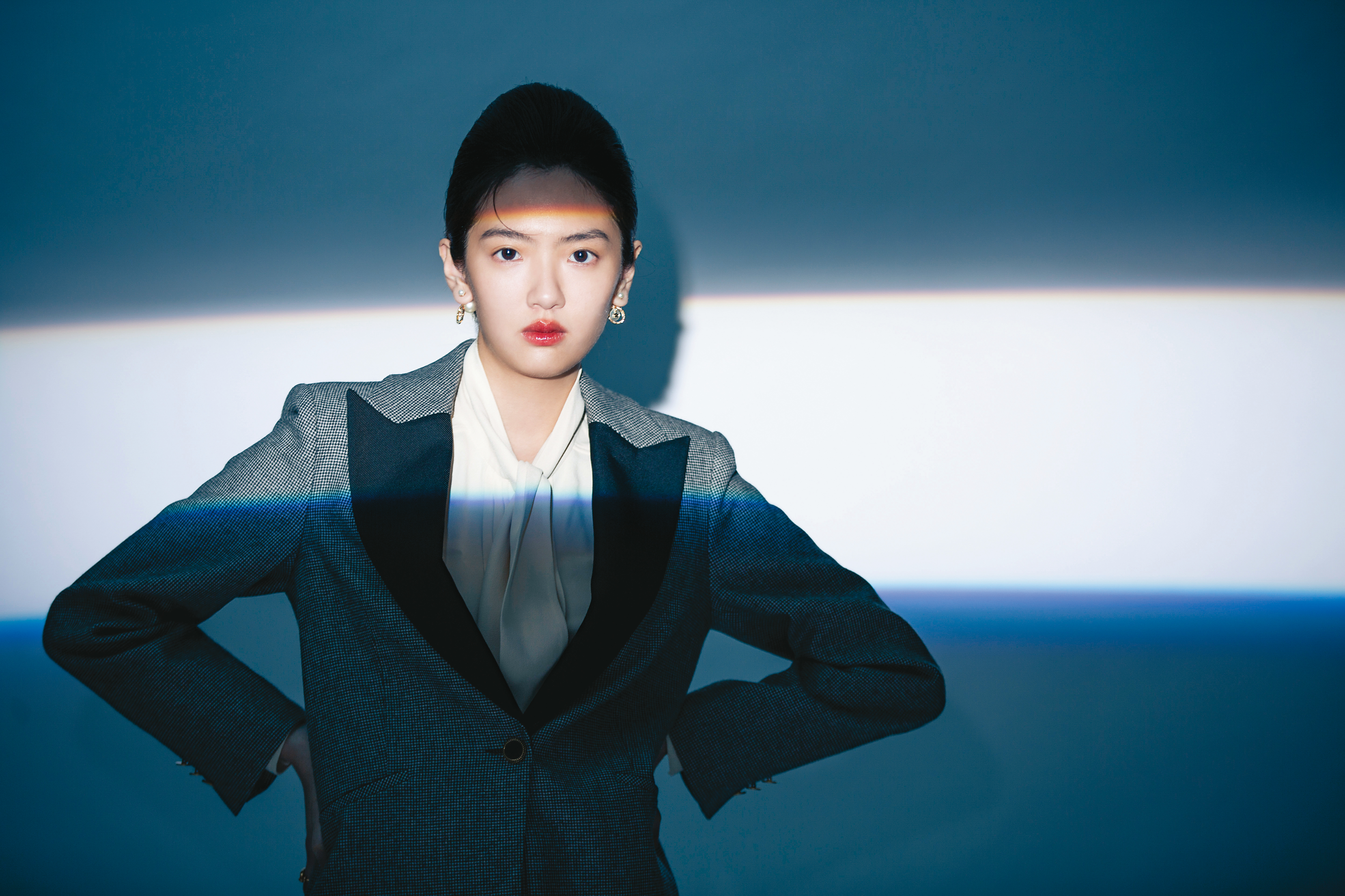 千鳥格黑色箭領西裝外套 NT$15,070 by SANDRO；奶油白繫帶襯衫 價格店洽 by CELINE；珍珠釘釦耳環 NT$24,000、 CD Navy金色戒指 NT$12,500 by DIOR。