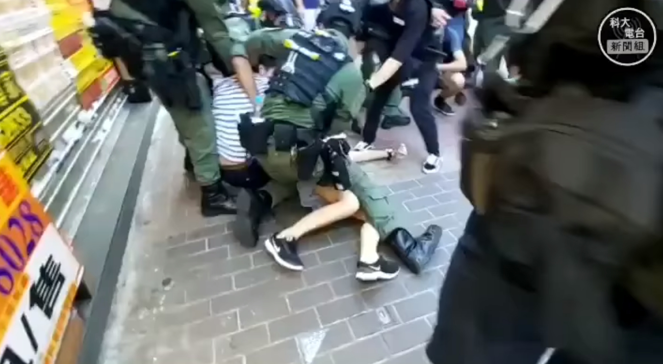 少女遭港警粗暴壓制,雖試圖反抗但根本無力抵擋。(翻攝科大電台新聞組臉書)