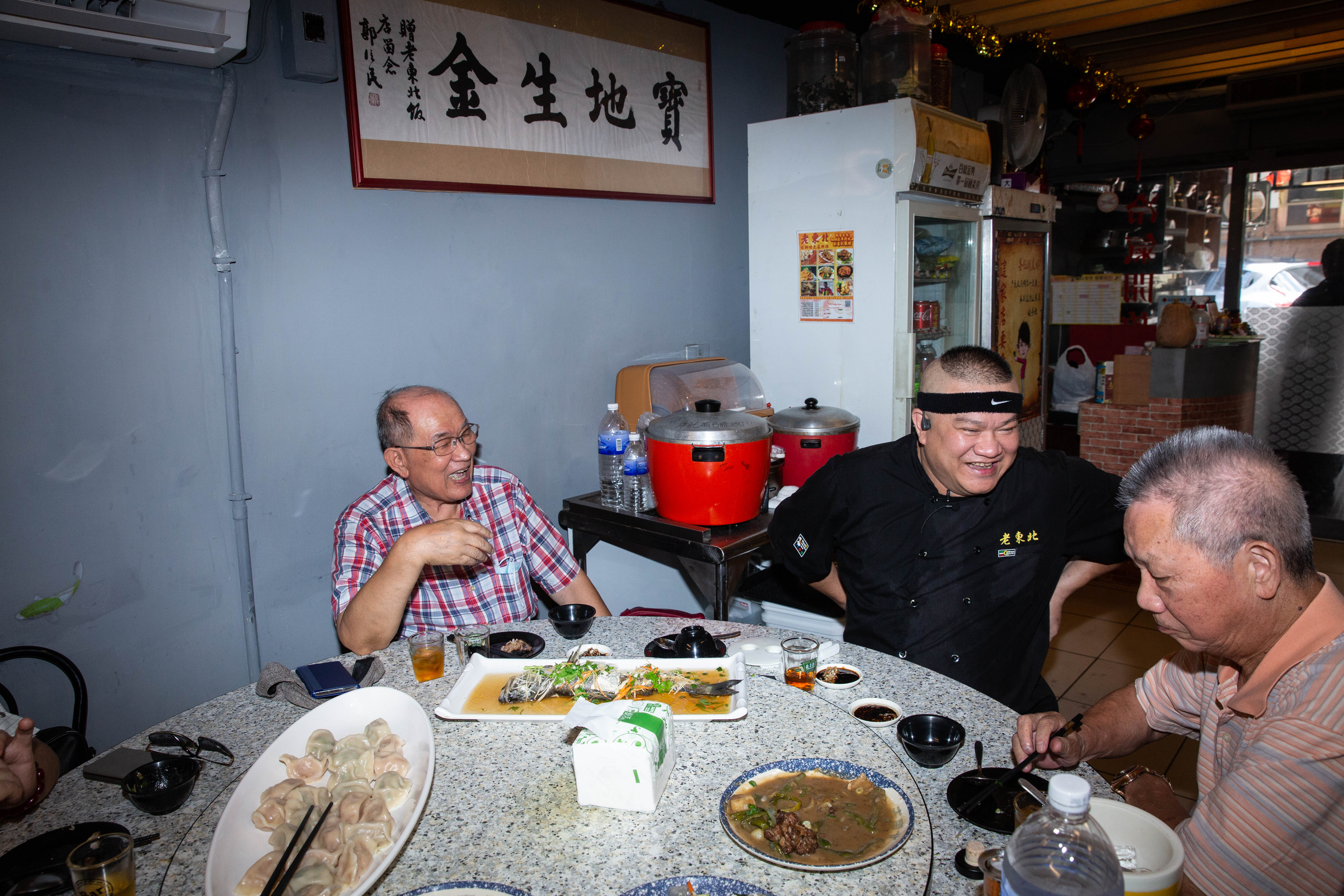 楊波（中）炒菜之餘會介紹客人東北菜的特色，與許多客人結為好友。