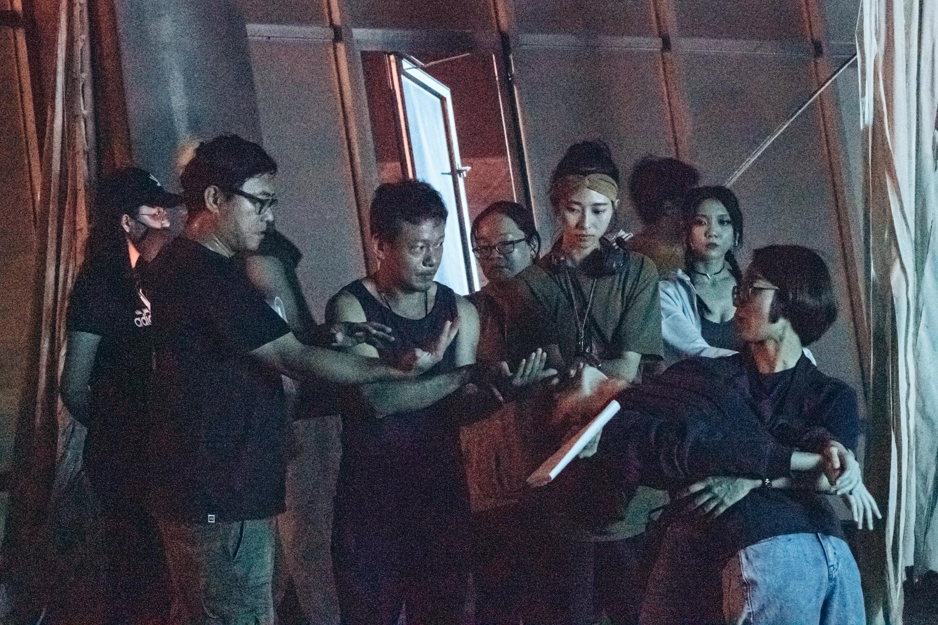 導演廖士涵（左二）與男主角李康生（中）等演員討論表演方式。（華影國際提供）