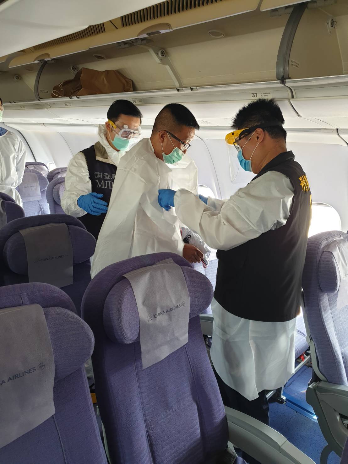 秦庠鈺在調查局、刑事局押解下，搭乘華航班機回台。（翻攝畫面）