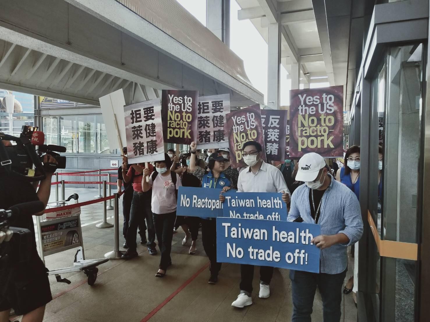 國民黨到機場「接機抗議」,高舉反萊豬標語。(翻攝自中國國民黨KMT推特)