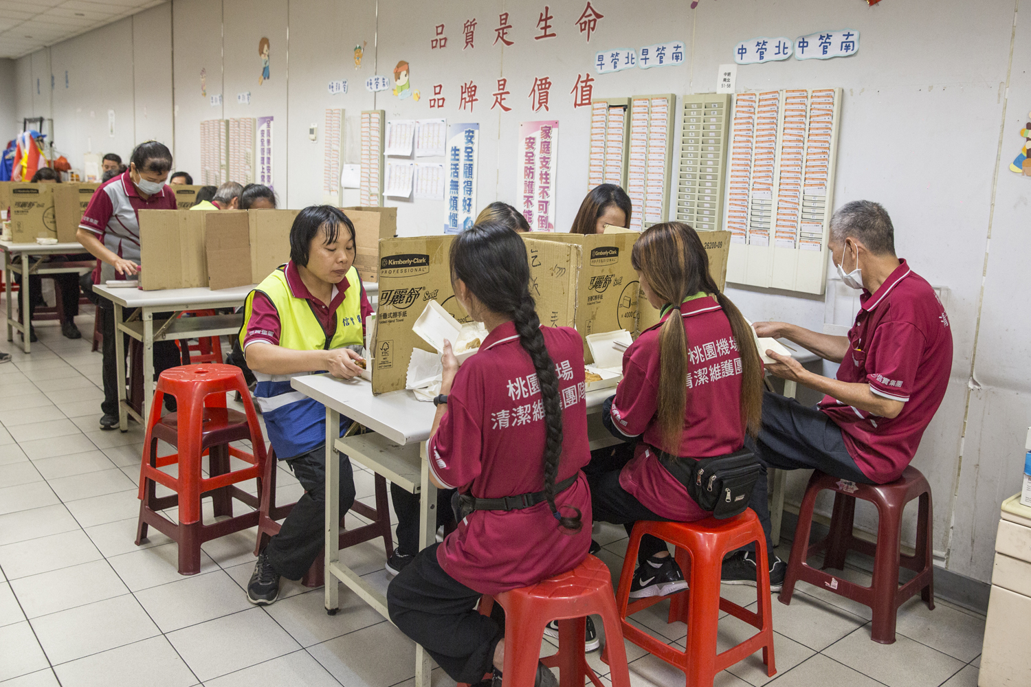 信實集團在桃園機場二航廈的員工，午餐時間會自行排好桌椅、擺上自製隔板再用餐，相當有紀律。