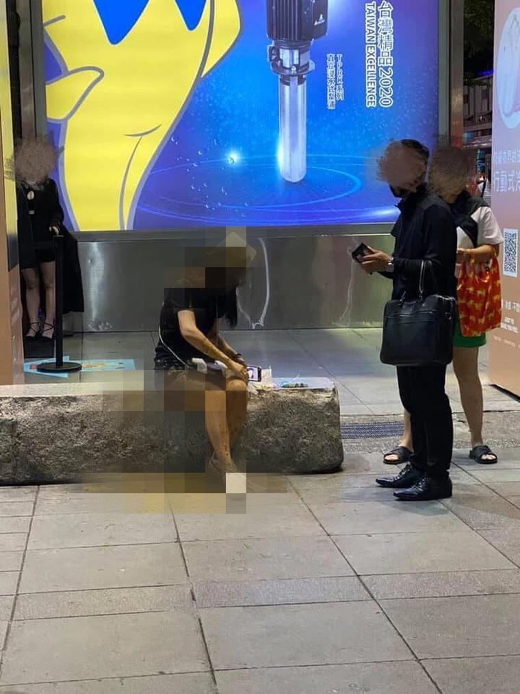邱姓女子獨坐在威秀廣場前，突然遭一名男子持水桶迎頭潑糞。（翻攝爆料公社）