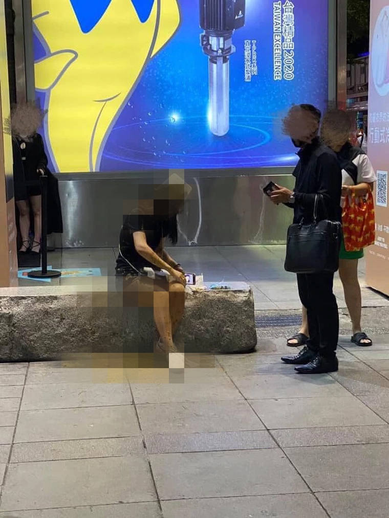 邱姓女子獨坐在威秀廣場前，突然遭一名男子持水桶迎頭潑糞。（翻攝爆料公社）