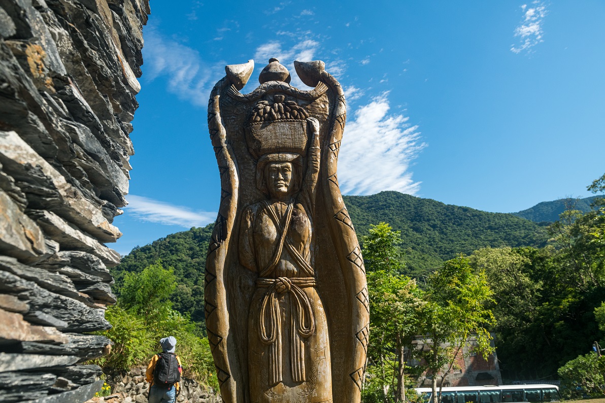 嘉蘭部落裡復刻頭目家前的木柱，刻有百步蛇、陶甕及小米圖樣。