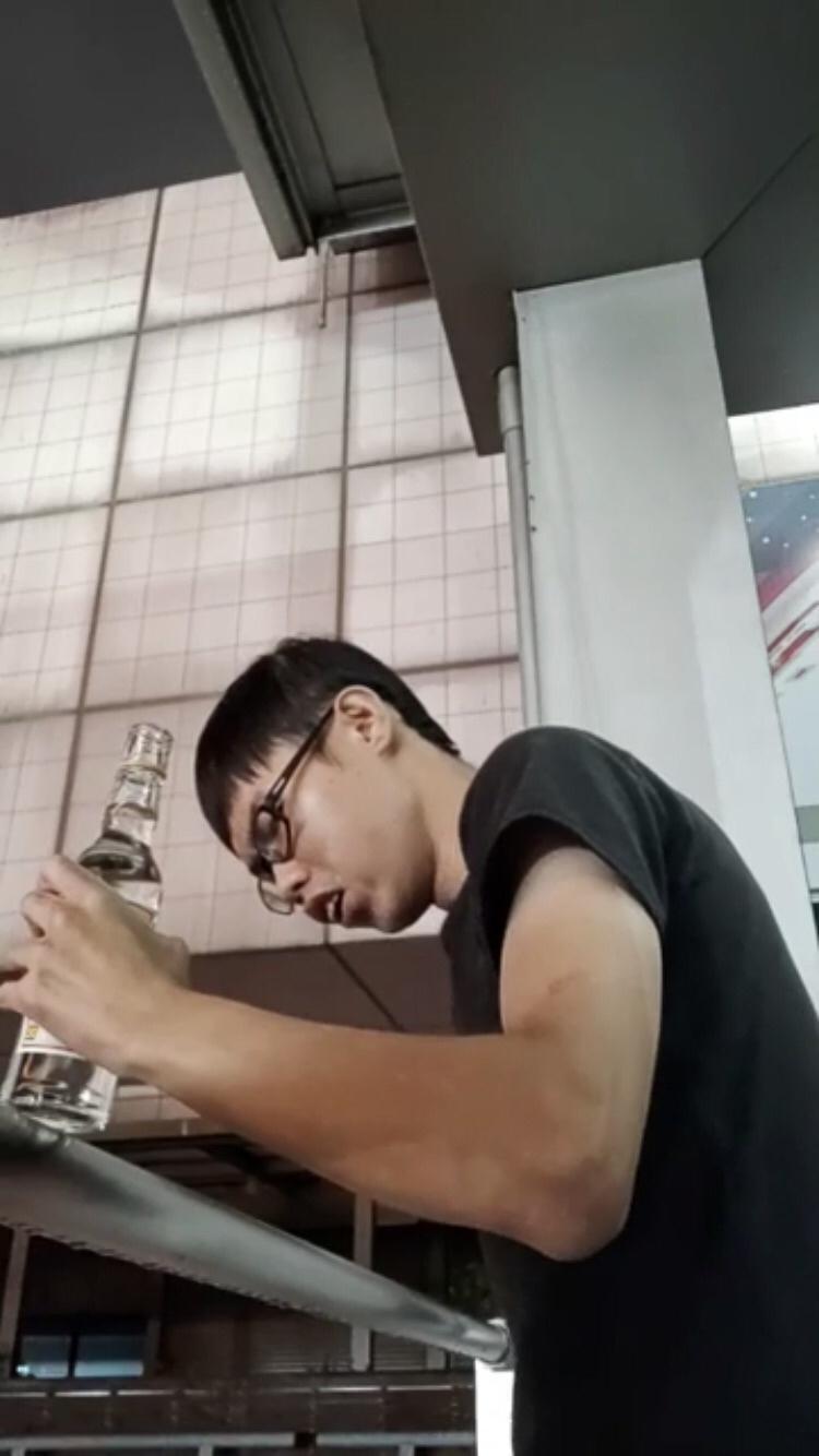 判決前，鄧佳華裝著不明液體的酒瓶跑到樓頂揚言自殺。（翻攝畫面）