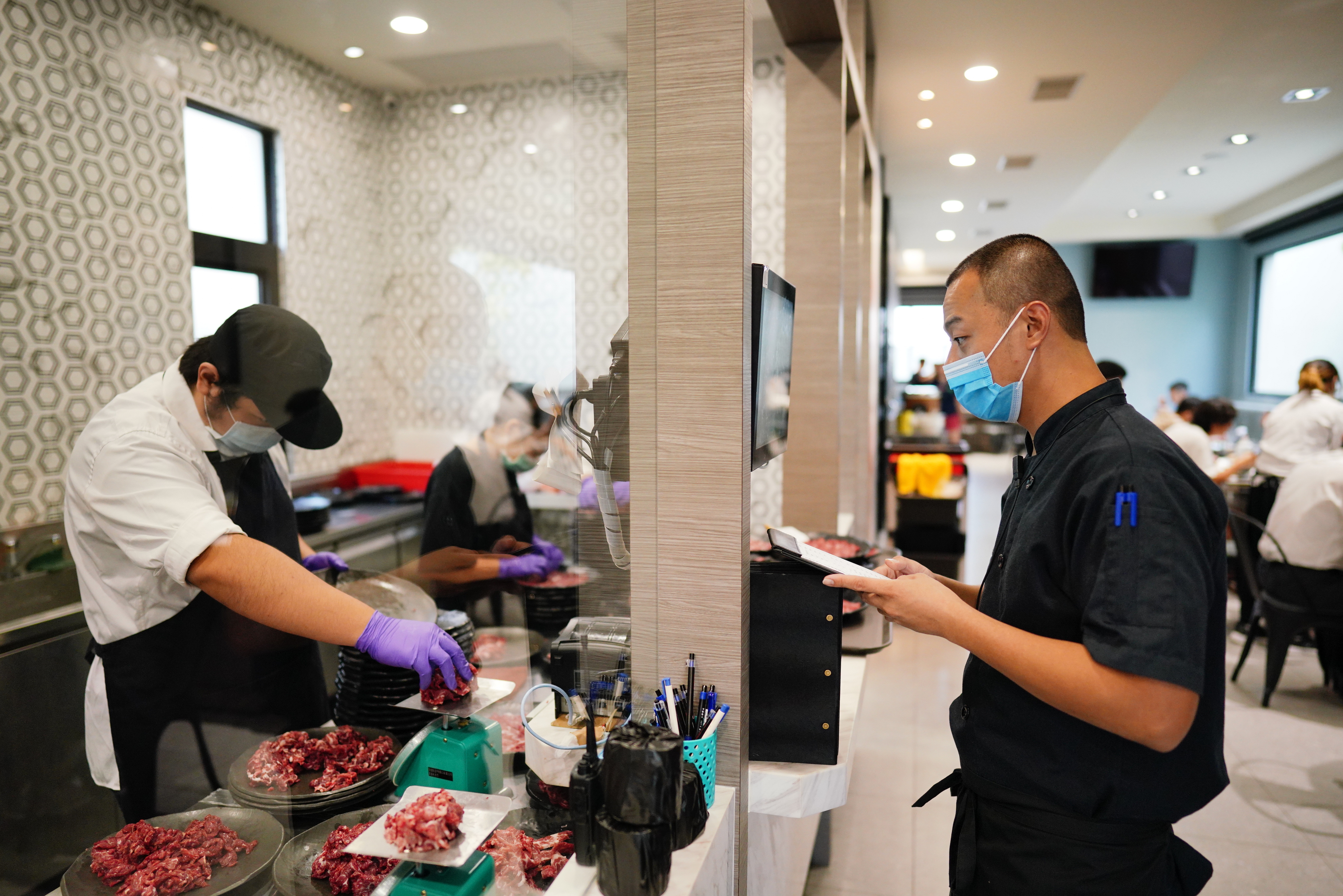 高中畢業就跟著父親沈大裕學習的沈偉峻（右），站在新店進門最醒目處接待客人。