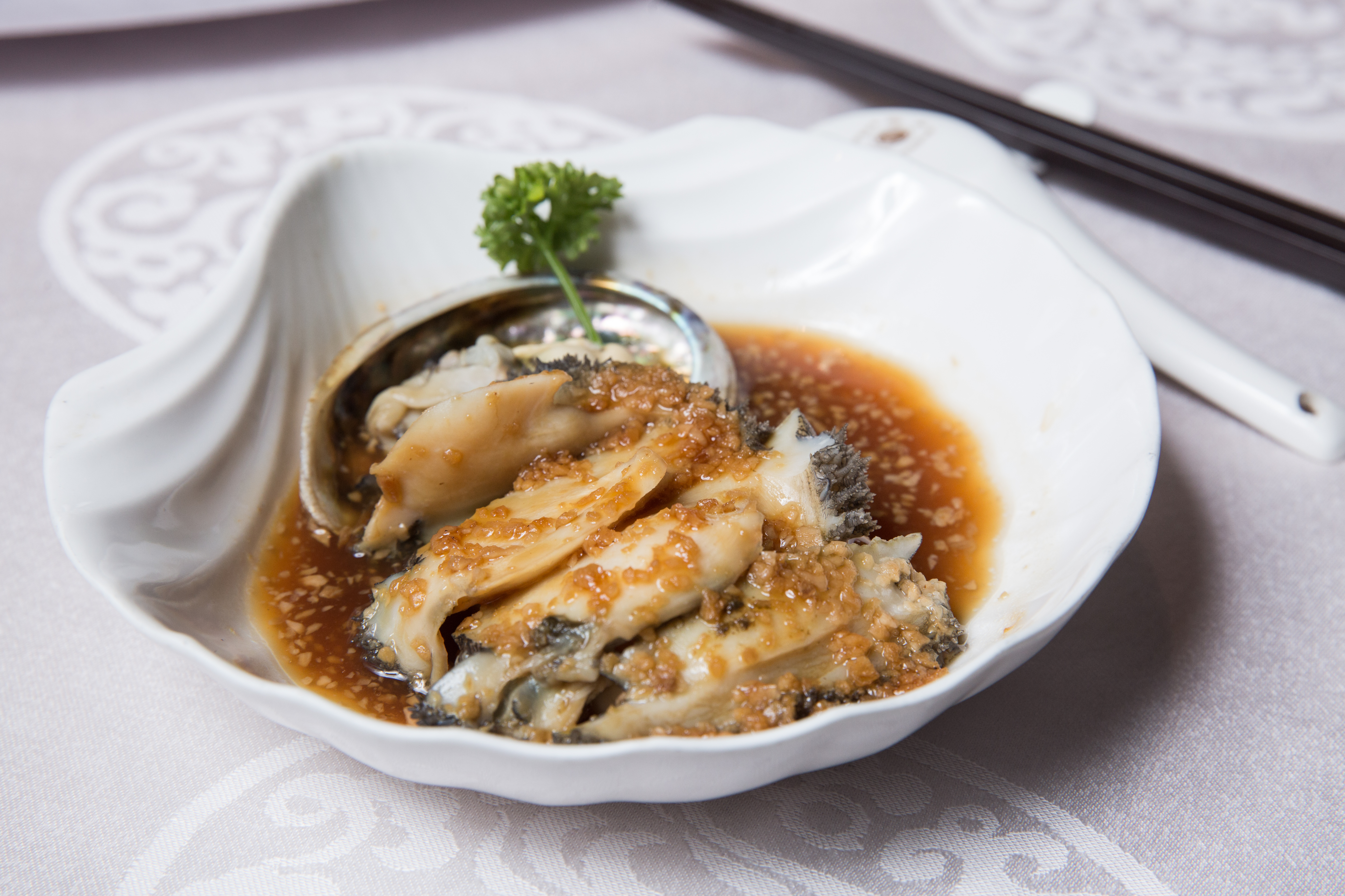蒜香鮑魚香氣十足，鮑魚個頭碩大，是莊添財宴客的指定菜色之一。