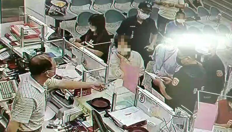 保七員警與行員在櫃檯前勸阻阿嬤匯款。(翻攝畫面)