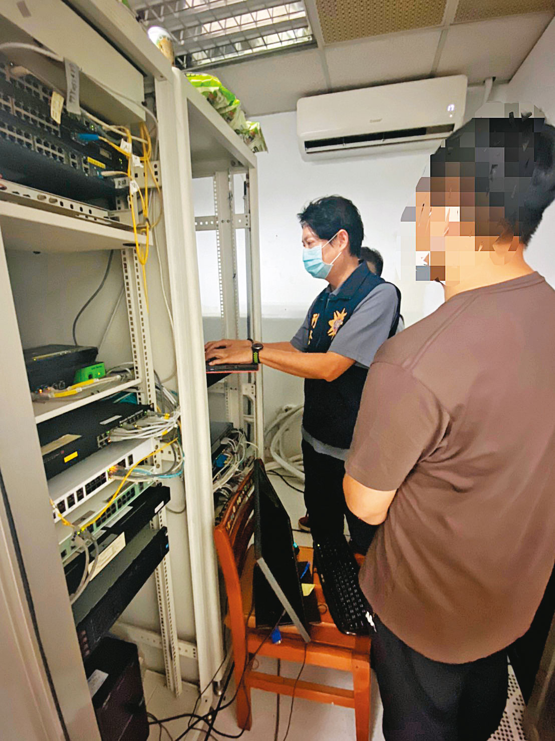 高雄警方日前搜索色情網站「承德路」的機房，並逮捕架設網站的王姓工程師（右）。（翻攝畫面）