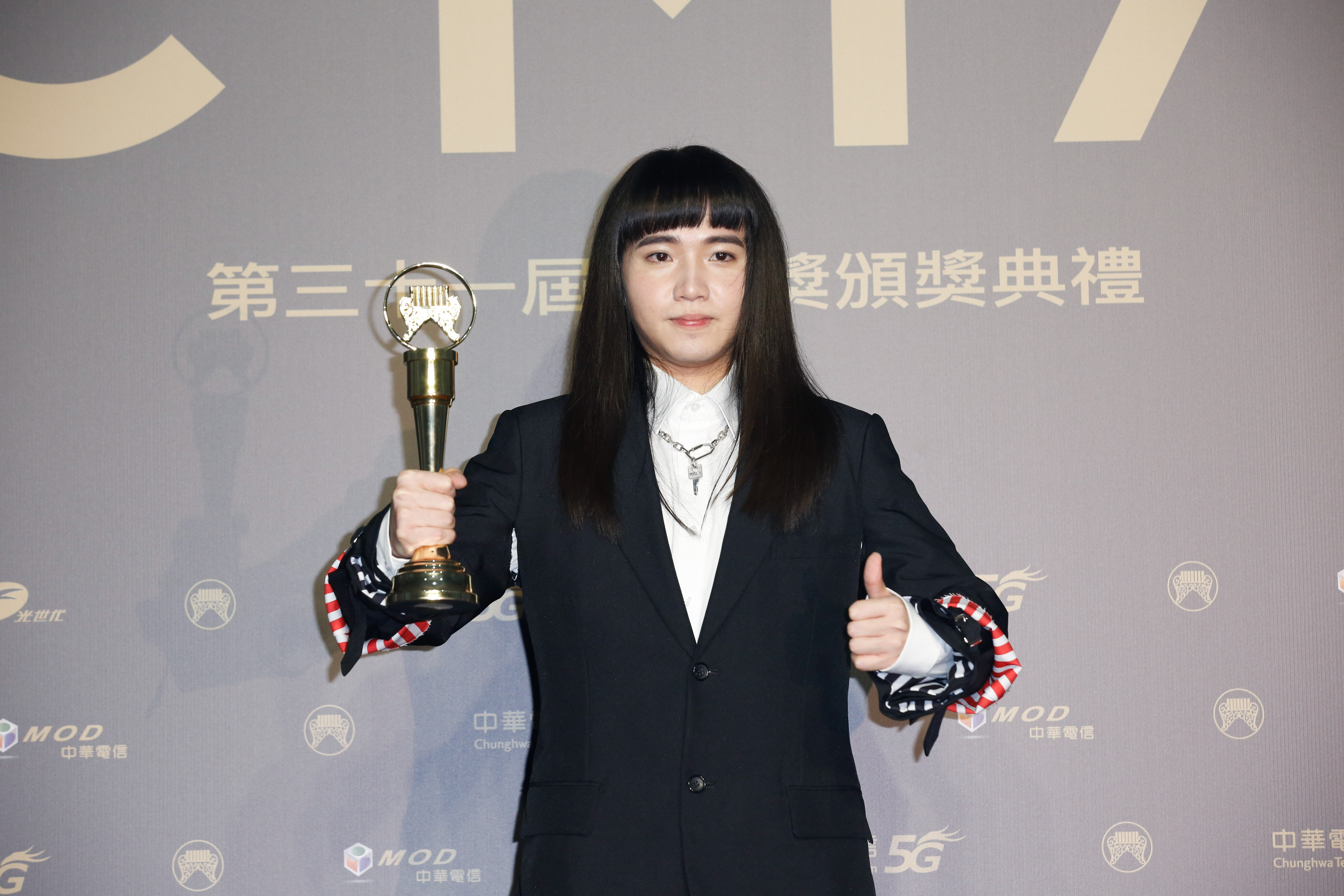持修在後台一手拿獎一手比讚，拍照時因太過緊張而身體顯得有些僵硬。