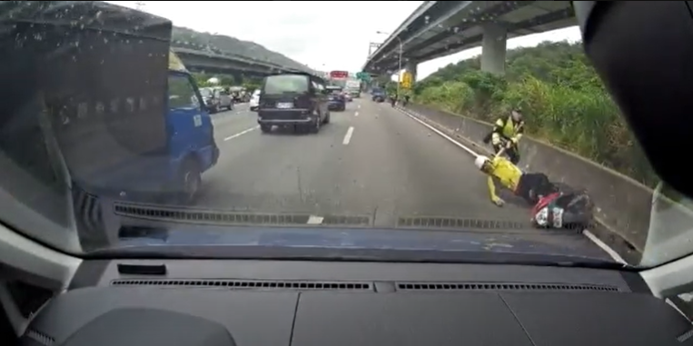 警方即時將被小貨車擦撞的趙男拉至路邊,險些遭後方車輛撞擊。(國道警察局提供)