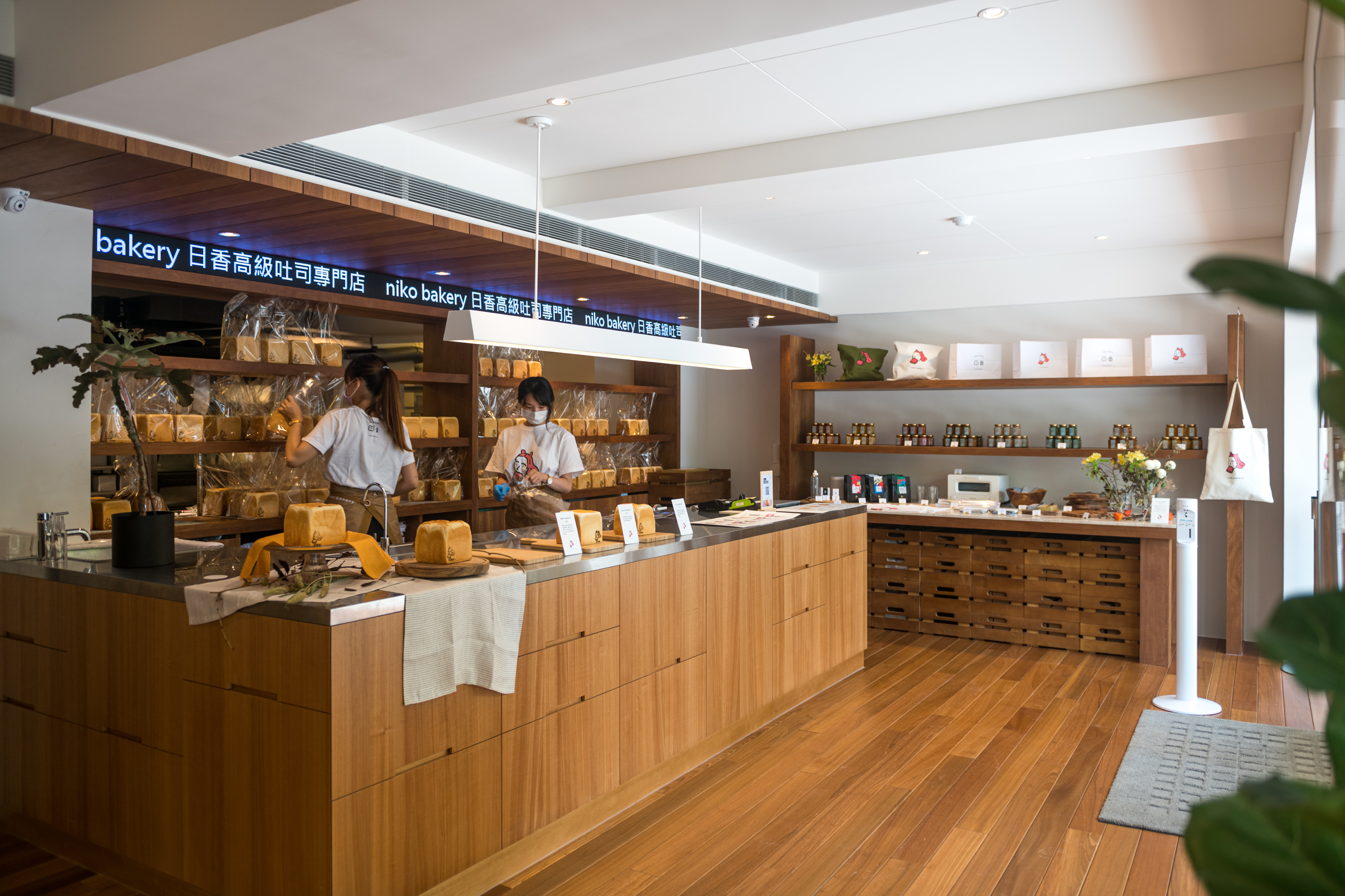 櫃檯後方木架不斷擺上新出爐的吐司，店內亦有富錦樹咖啡豆、日香限定商品及生活選物。