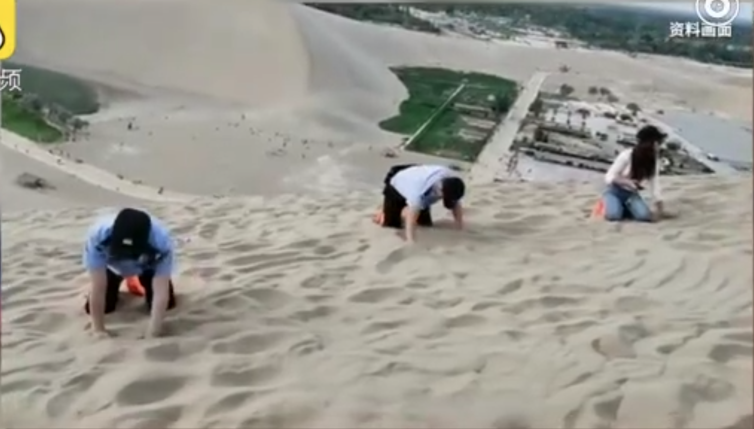 員警跪在沙漠上，徒手挖沙尋找遺失的手機。（翻攝自梨視頻微博）