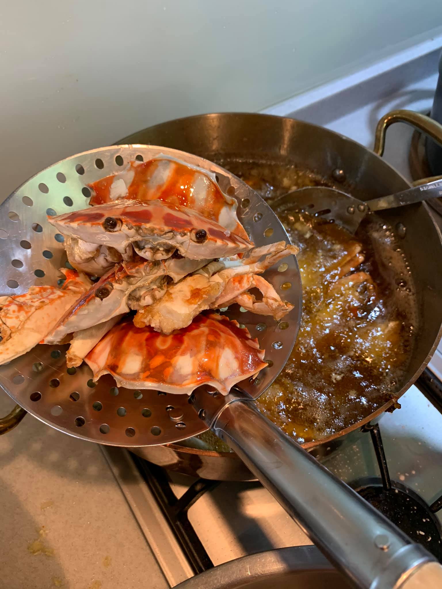 蟹塊炸熟後，撈起瀝油。
