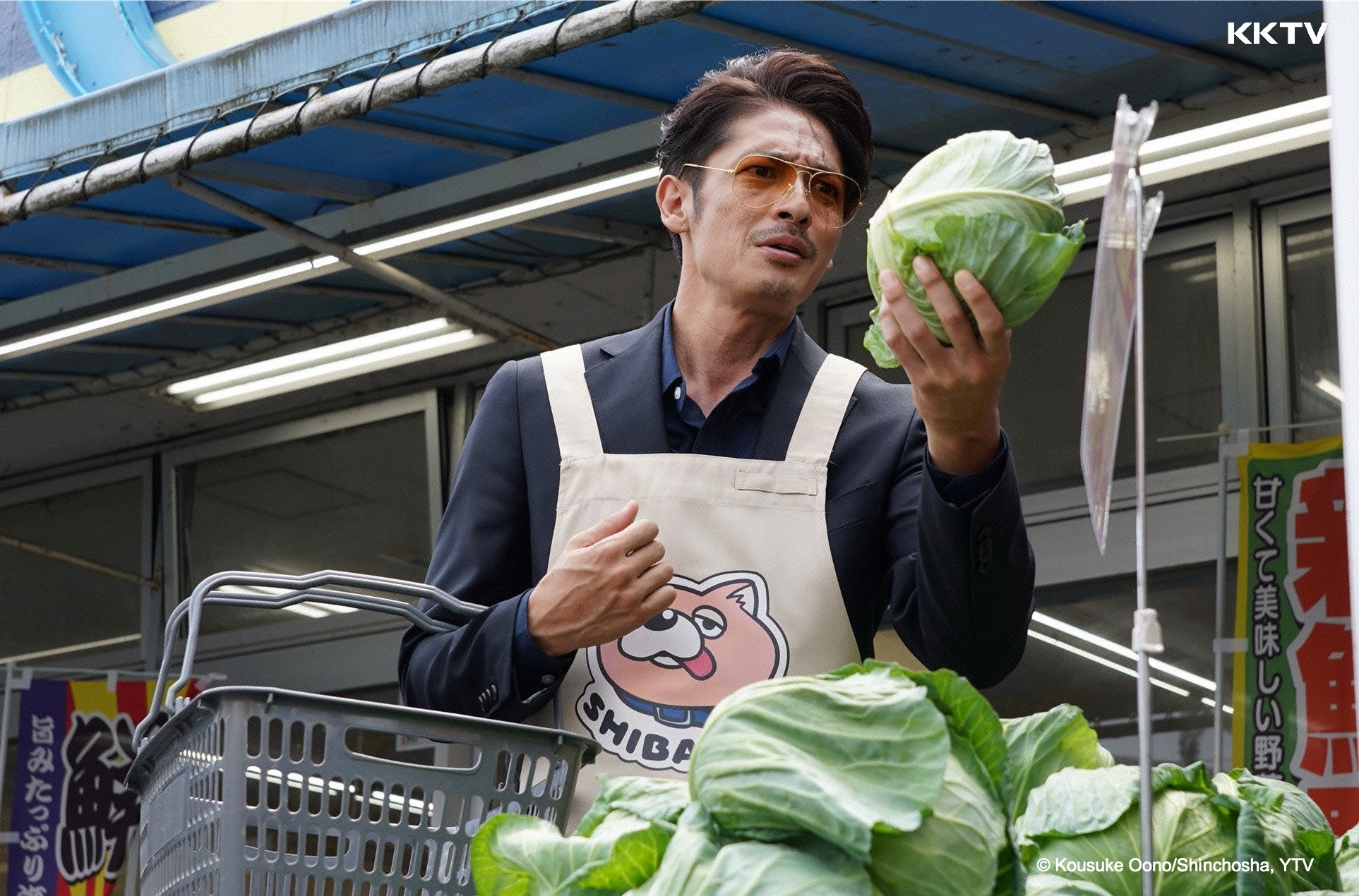 玉木宏在新劇《極道主夫》化身黑道出身的家庭主夫，穿著柴犬圍裙買菜。（KKTV提供）
