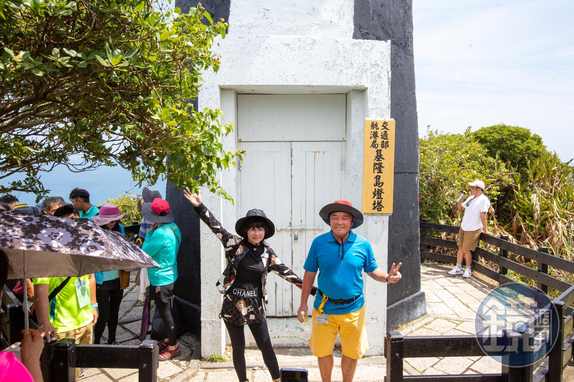 遊客在基隆島燈塔前開心留影。