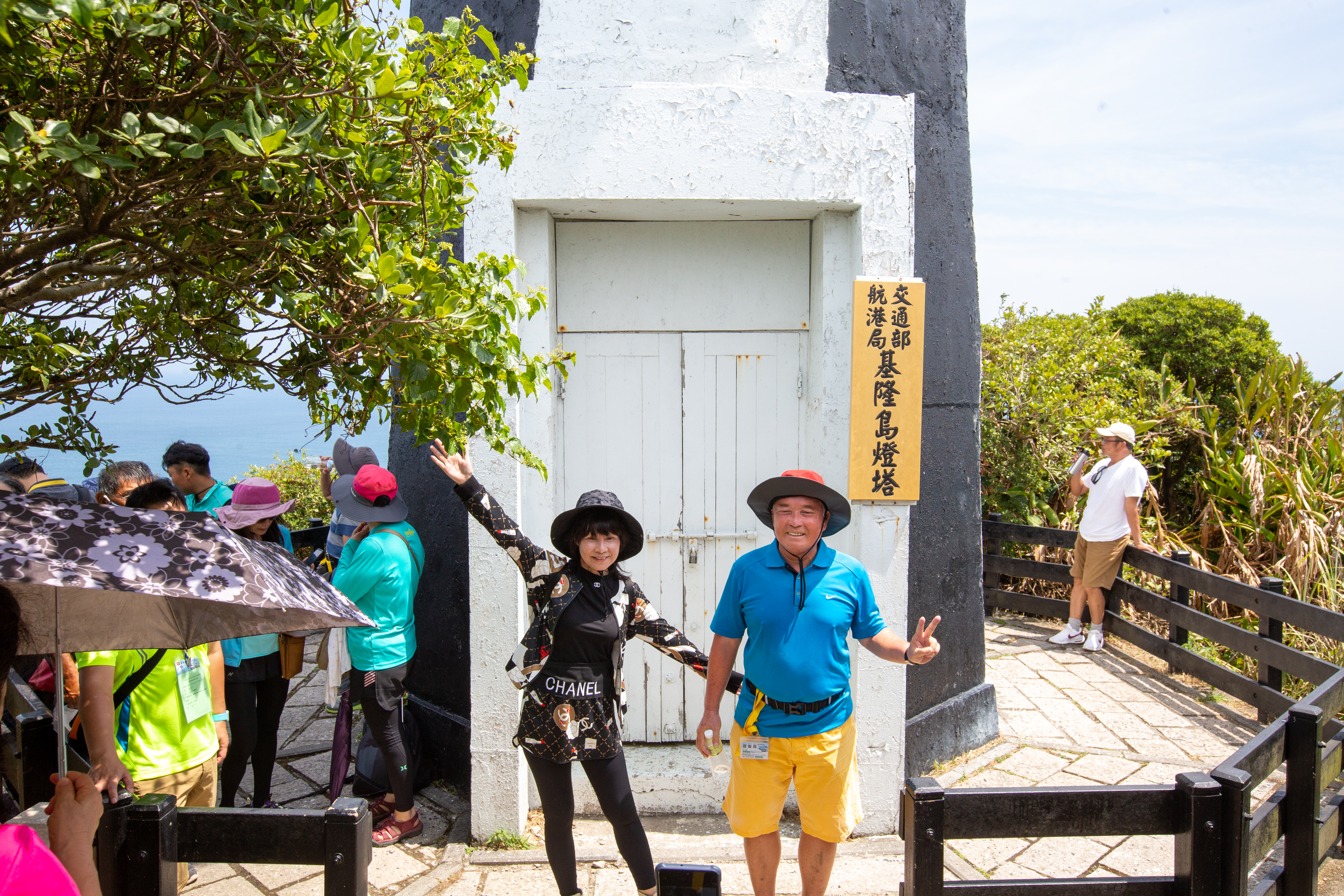 遊客在基隆島燈塔前開心留影。