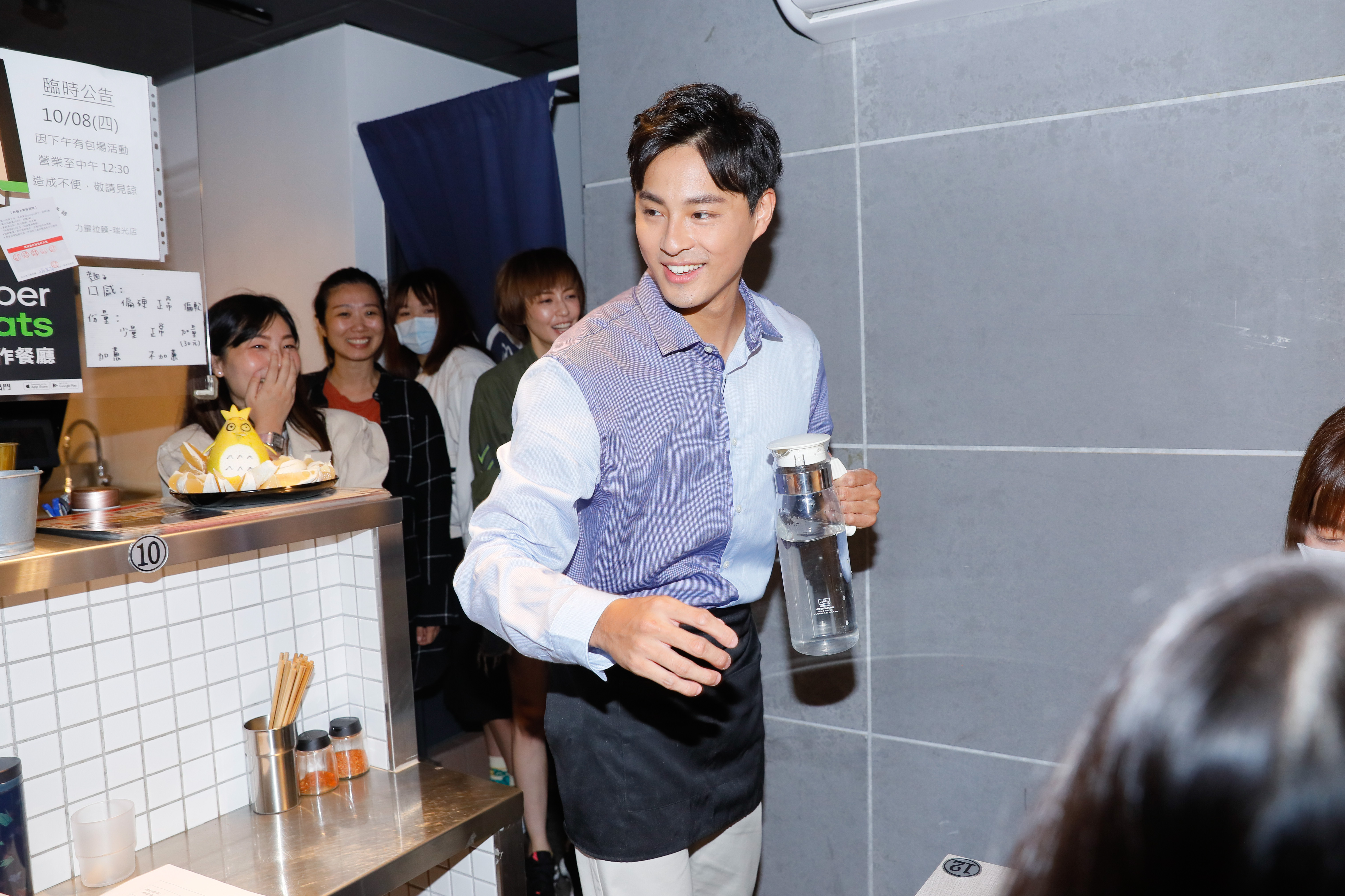 孫其君開拉麵店，幫客人倒水。