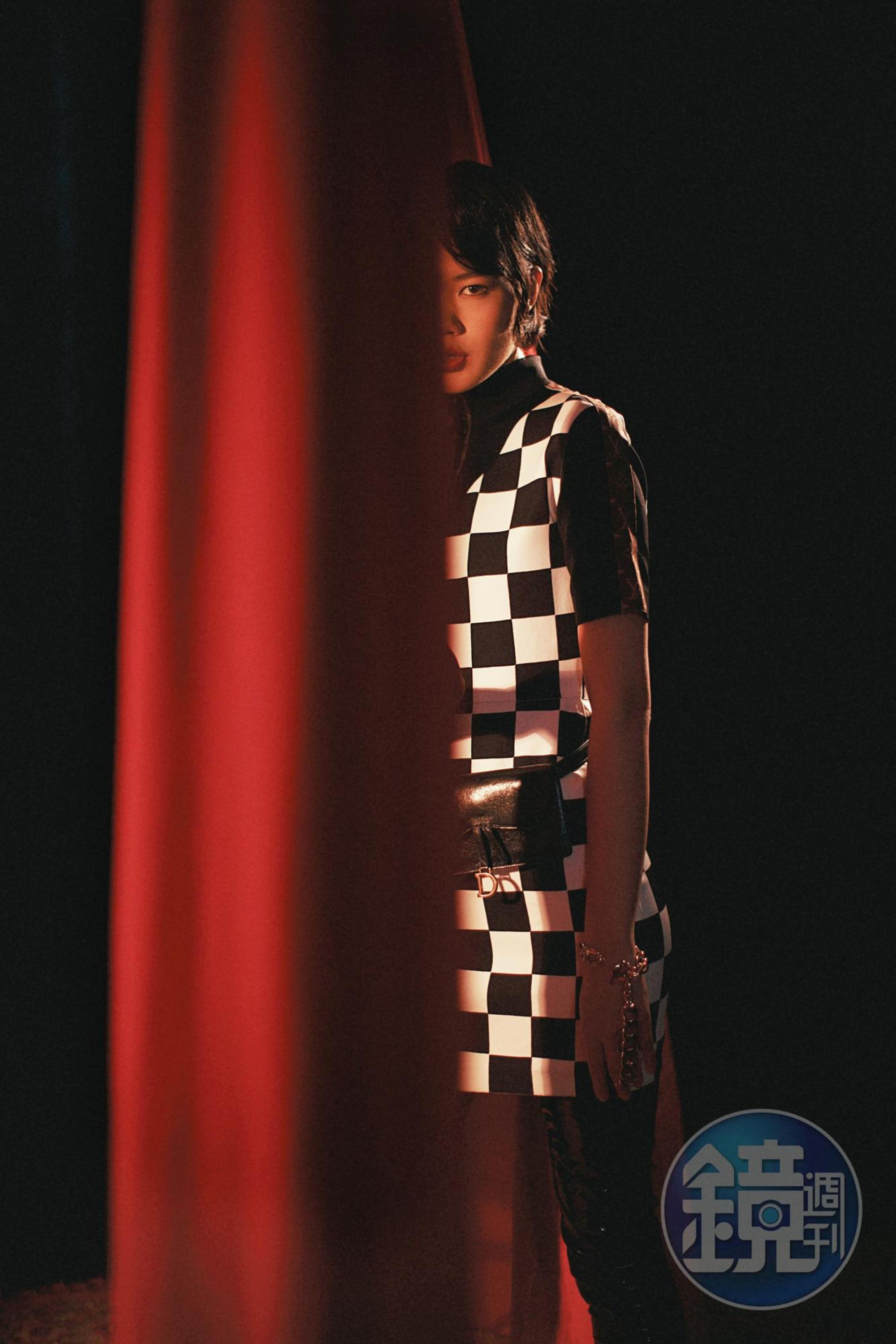 Damier技術性針織高領連身裙NT$95,500 by LOUIS VUITTON；Saddle黑色裂紋仿舊小羊皮馬鞍方形腰包NT$38,000 by DIOR；手鍊（原為項鍊）  價格店洽 by SAINT LAURENT