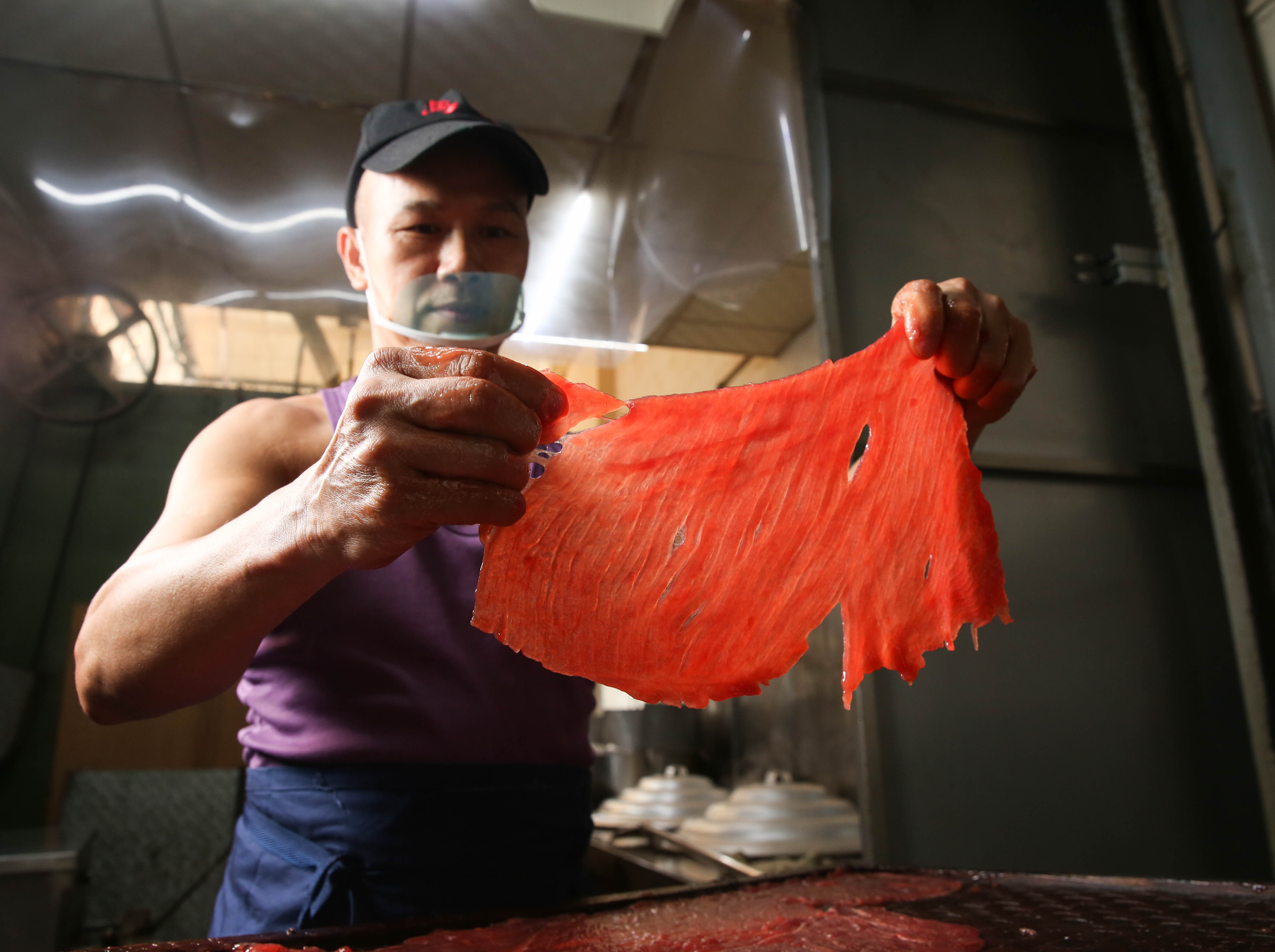 葉日傳將醃漬過的肉乾，趁完全退冰前，像拼拼圖般一塊塊披在竹篩上。