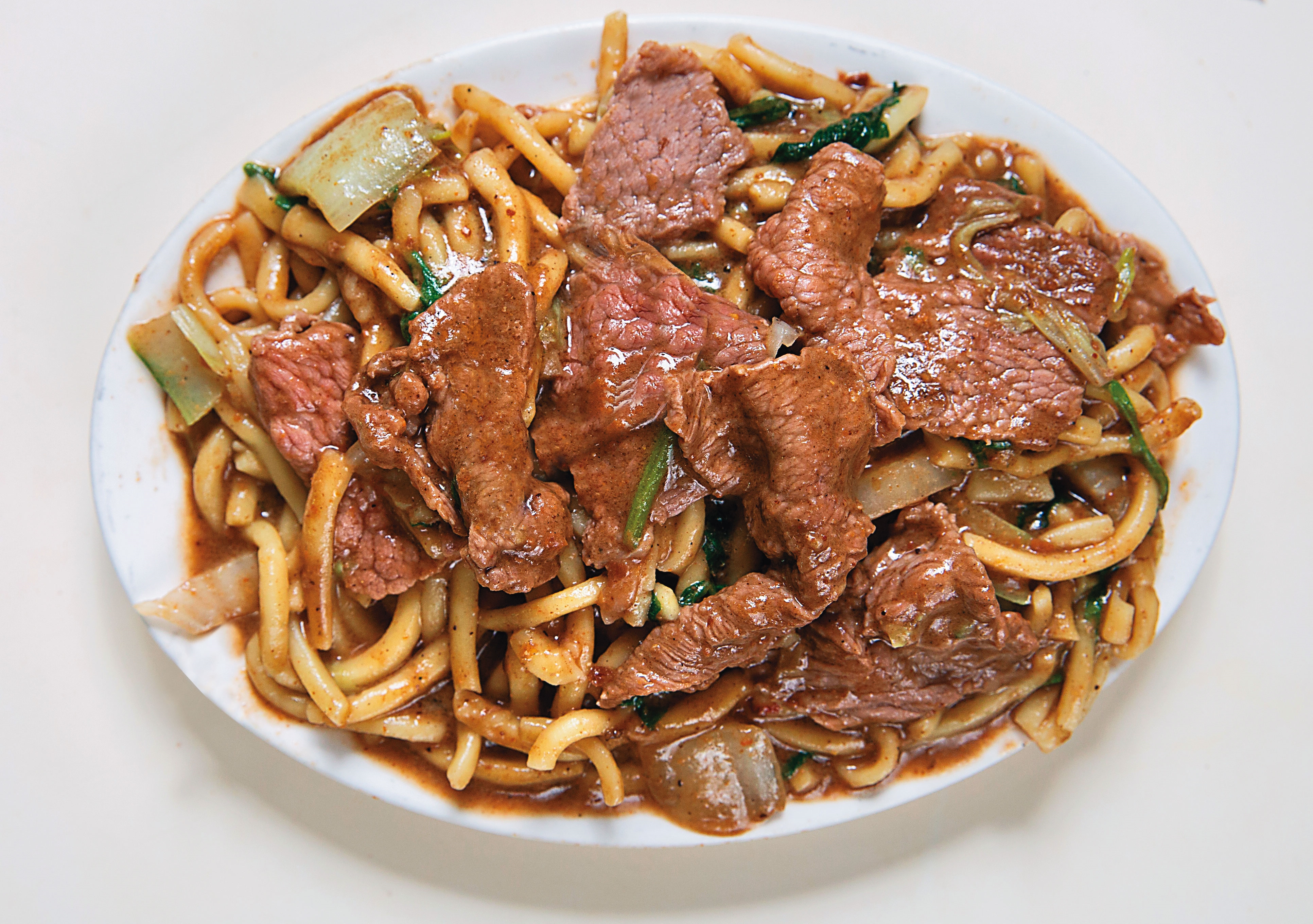 大哥黃沛峰說，沙茶牛肉炒麵好吃的關鍵在按摩，要讓麵條、肉汁與沙茶醬相互揉合。（80元／份）