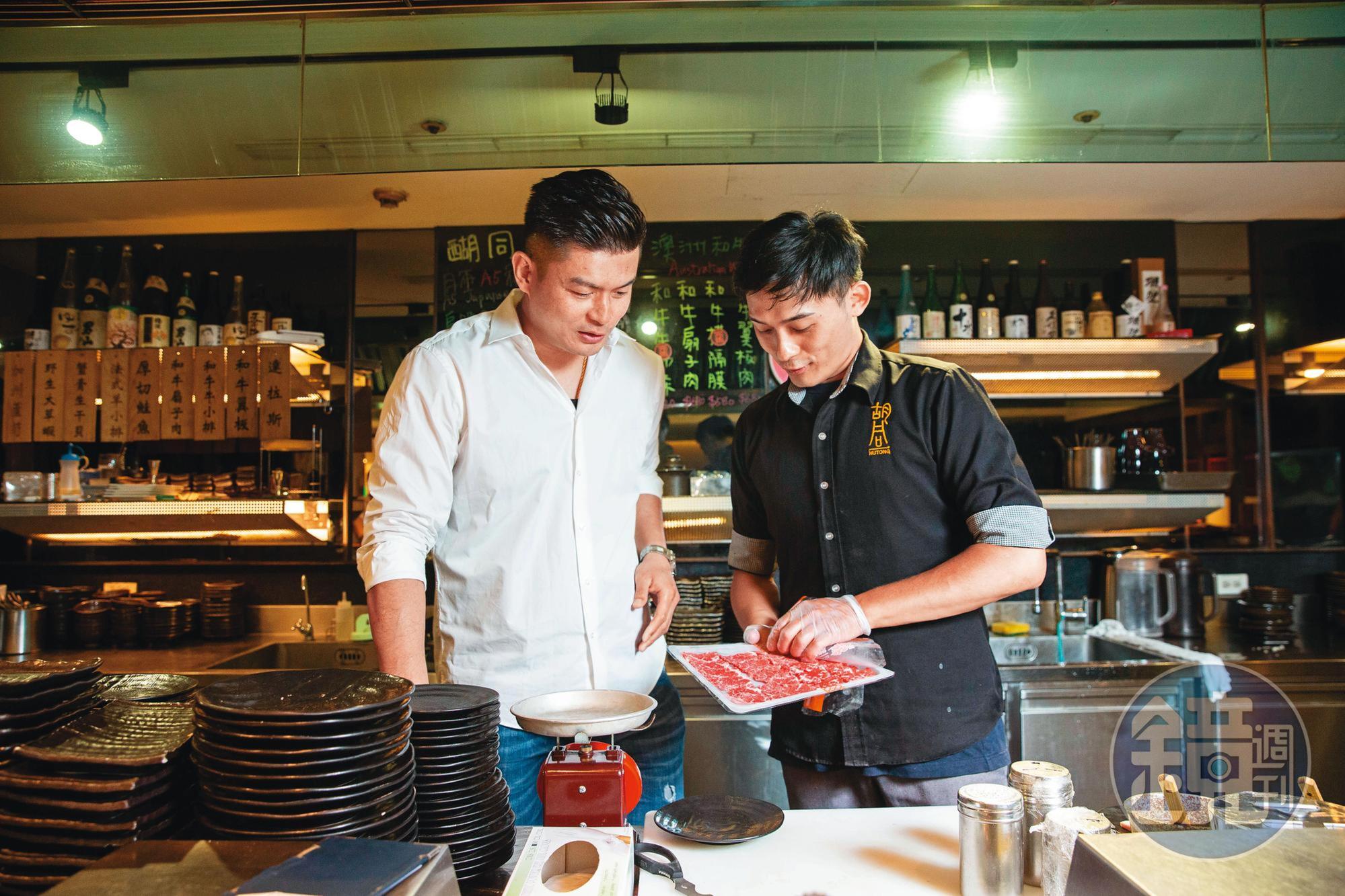 吳念忠(左)巡視店面時,再次檢視肉品品質是否合格。