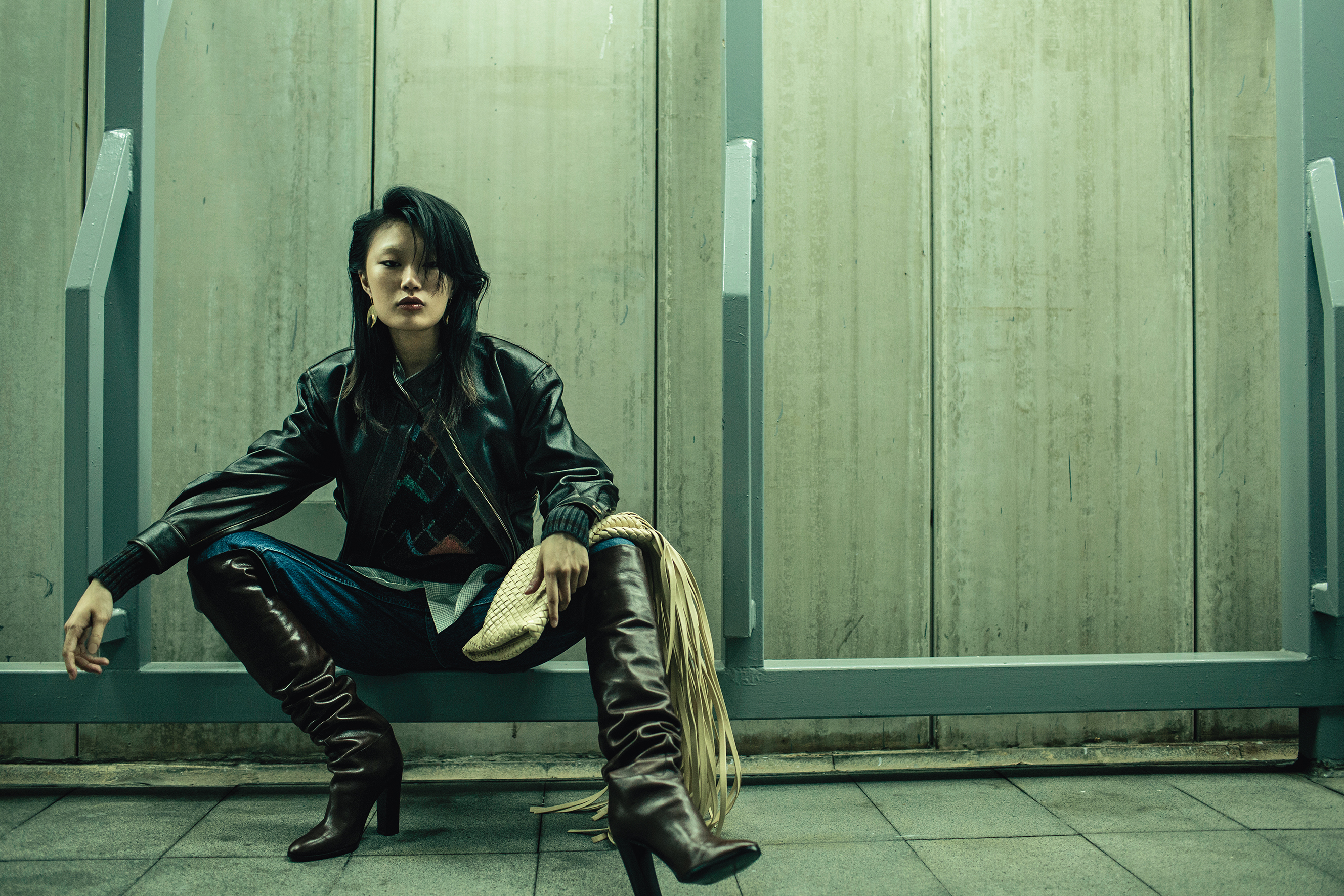 深咖啡色皮革短版皮夾克 NT$27,590 by SANDRO／菱格紋毛衣 NT$74,000 by DIOR／細格襯衫 NT$72,000 by DIOR Painter boy／丹寧褲 NT$3,990 by LEVI'S／深咖啡色長筒皮靴 價格店洽 by CELINE／耳環 價格店洽 by CELINE／Crisscross編織小羊皮流蘇手拿包 NT$142,900 by BOTTEGA VENETA