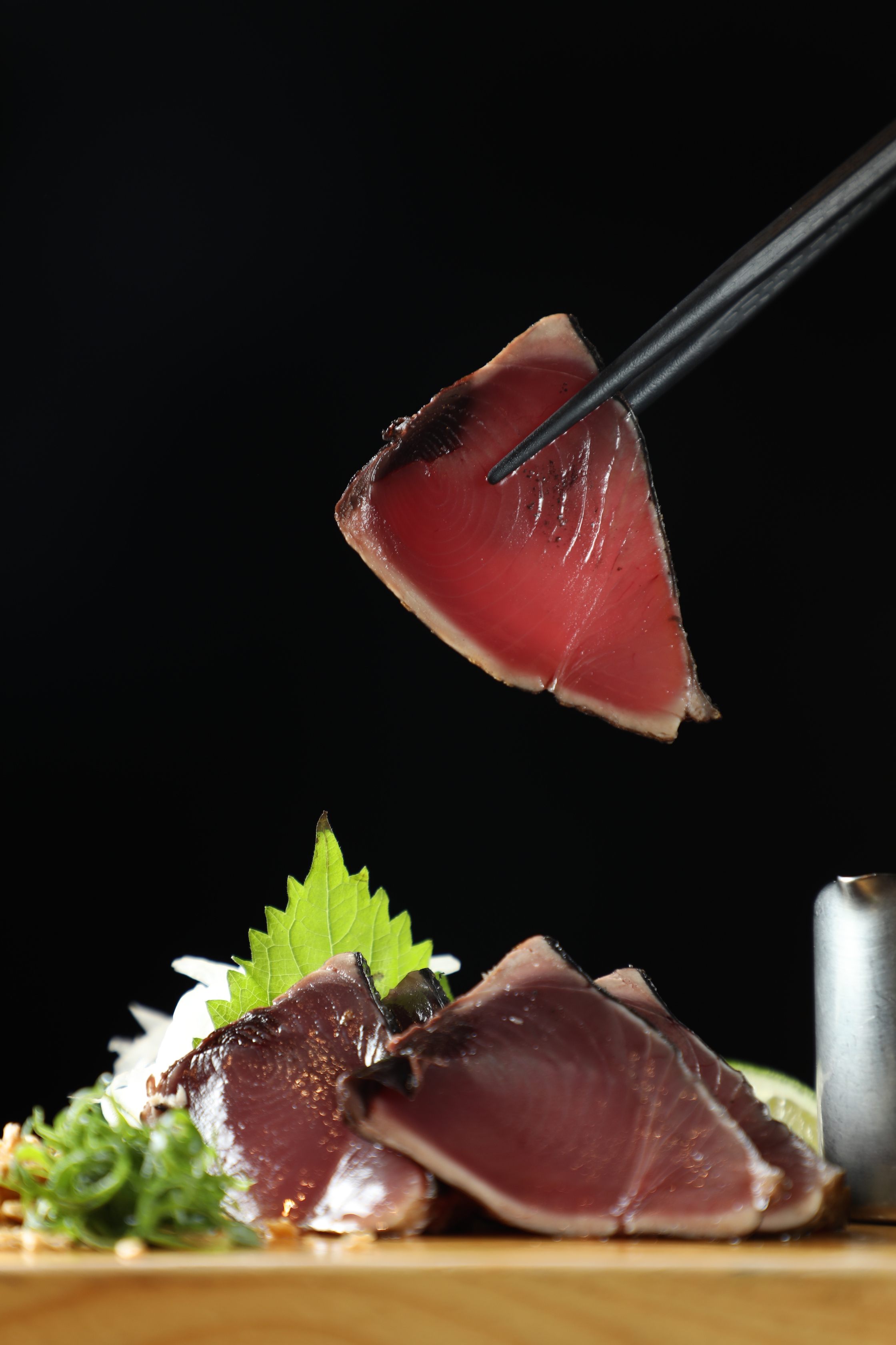 「鰹魚稻草燒」搭配洋蔥、山葵、蒜粉吃，毫無紅肉魚常見的腥氣，選料確實用心。（250元／份）