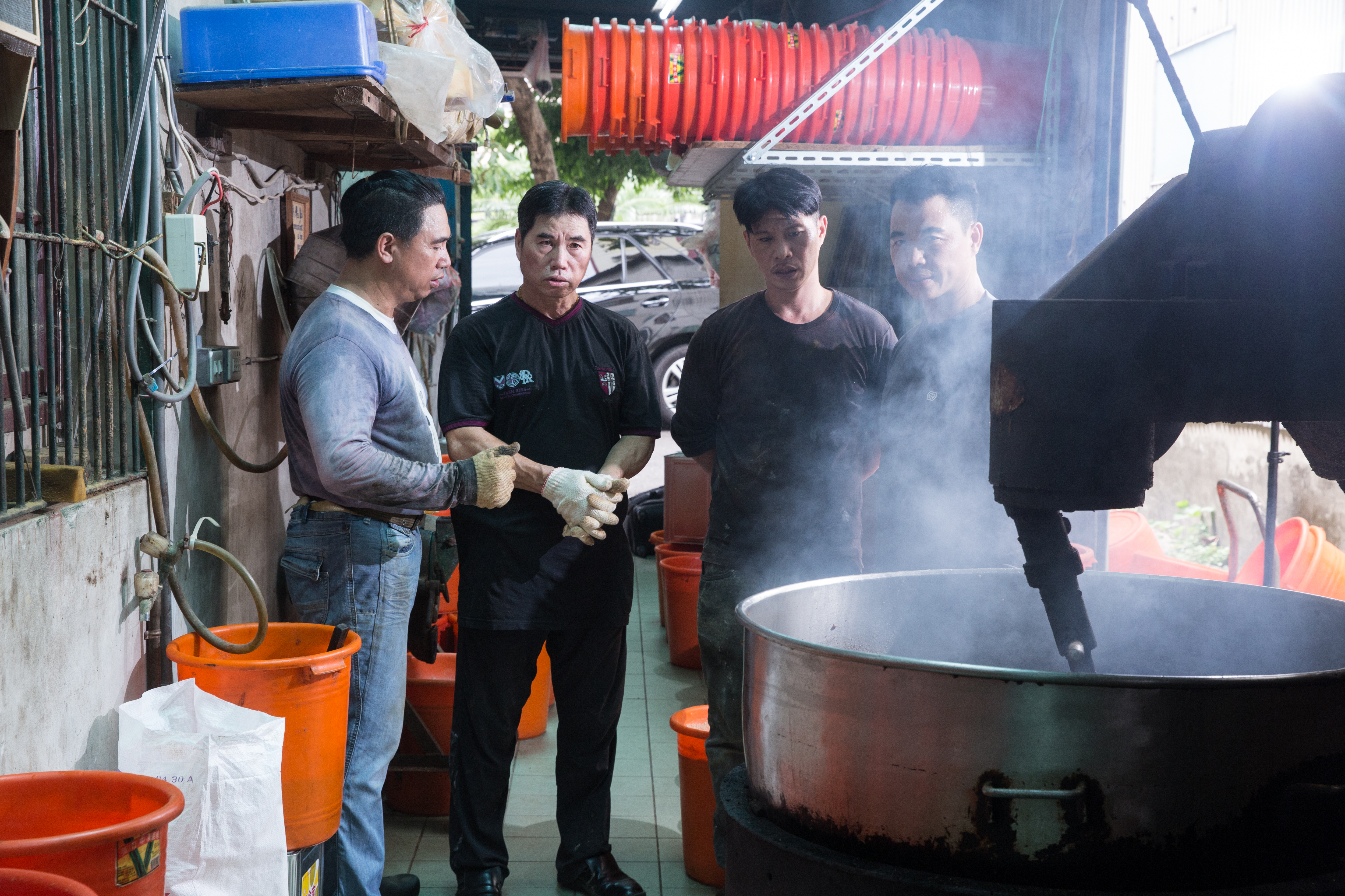 採訪這天，黃家的第二、三代圍在一只用了50多年的白鐵大鍋旁，緊盯沙茶翻炒的過程。（左起：三弟洪沛璔、大哥黃沛峰、第三代黃國樑、四弟黃沛閎）
