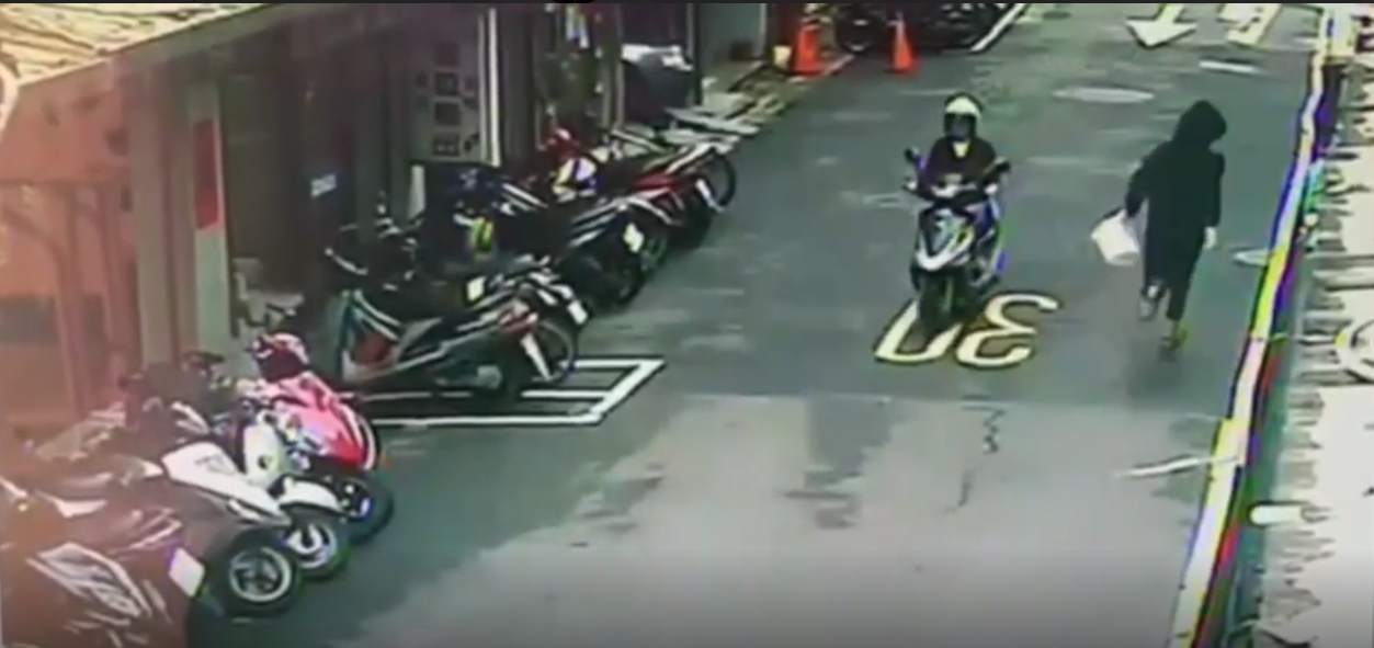 一名黑衣人持白色塑膠桶，朝港人餐廳潑雞屎後狂奔逃逸。（翻攝畫面）