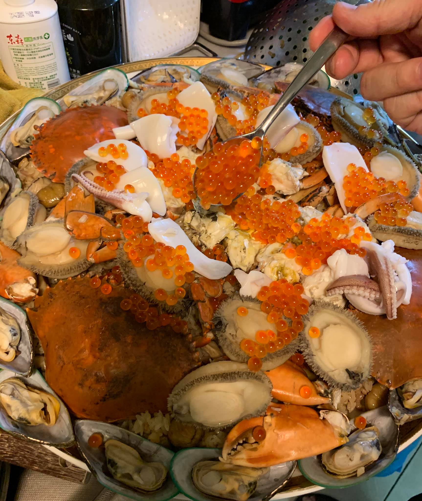 逐一放上鮑魚、淡菜、透抽、鮭魚卵。
