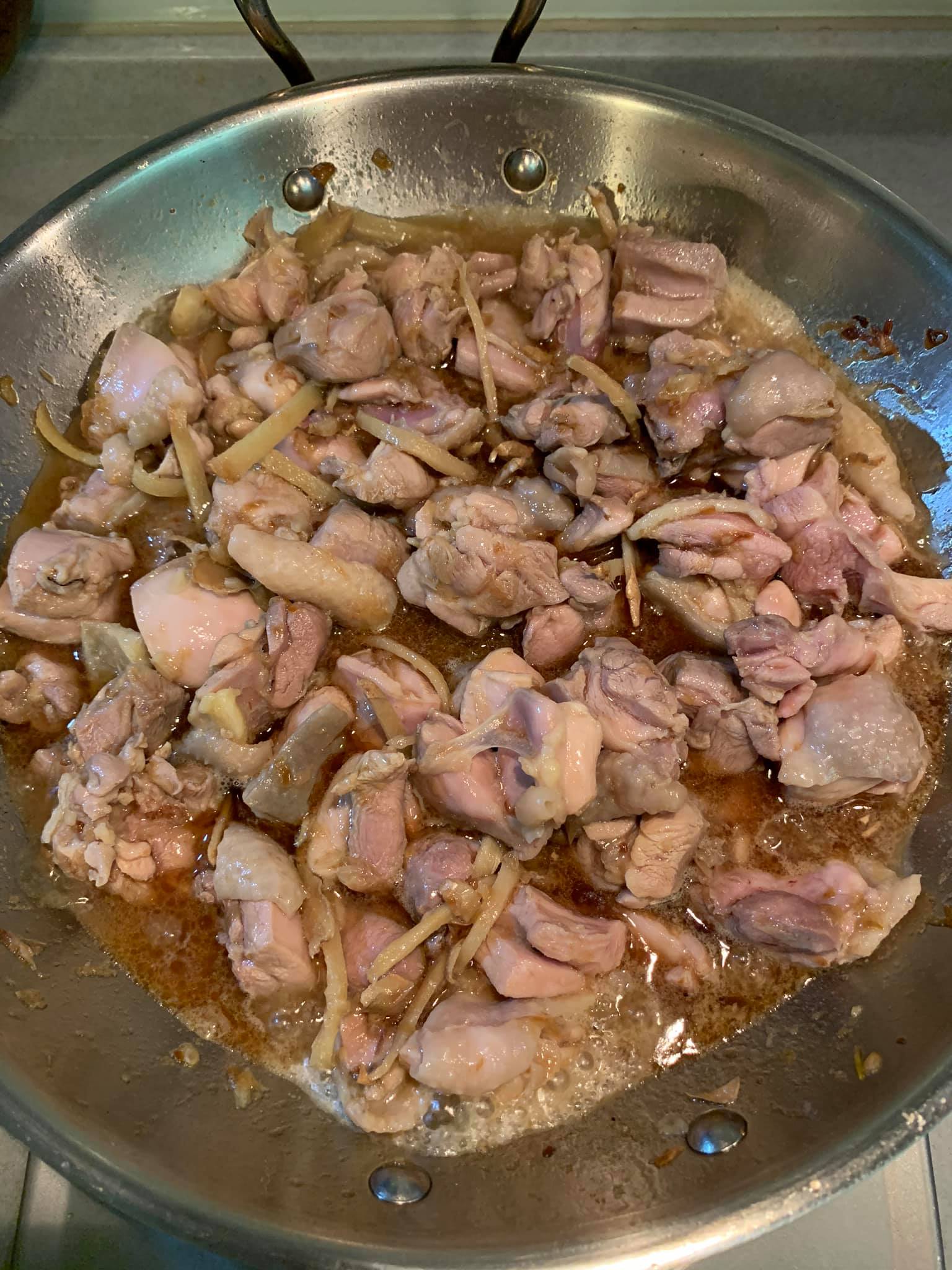 加入米酒，湯汁不用太多，這不是吃雞酒，是做麻油雞飯。熟了便撈起雞塊。