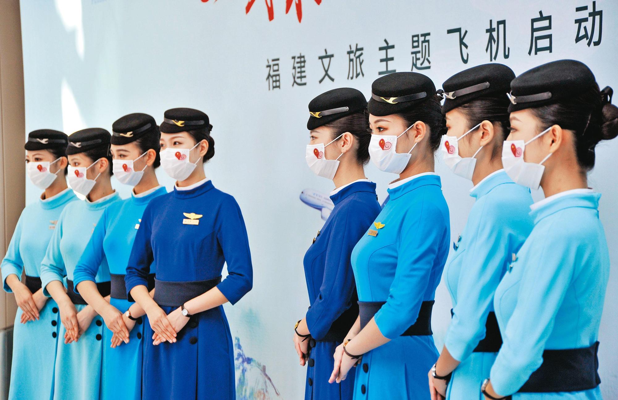 中國民航業載客率暴跌,機組人員為了防疫全得戴上口罩。(東方IC)